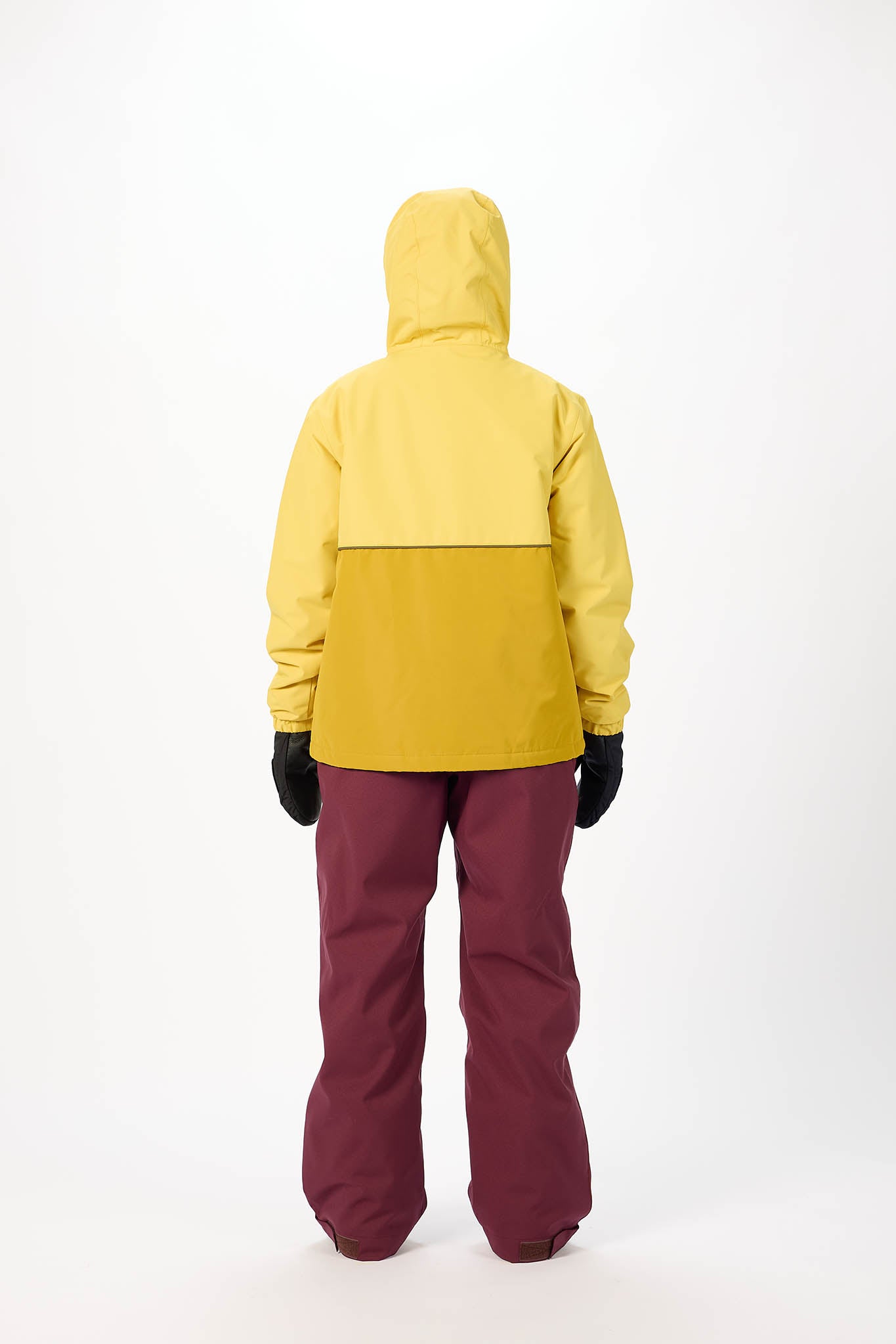 Person wearing a yellow jacket and maroon pants on a white background