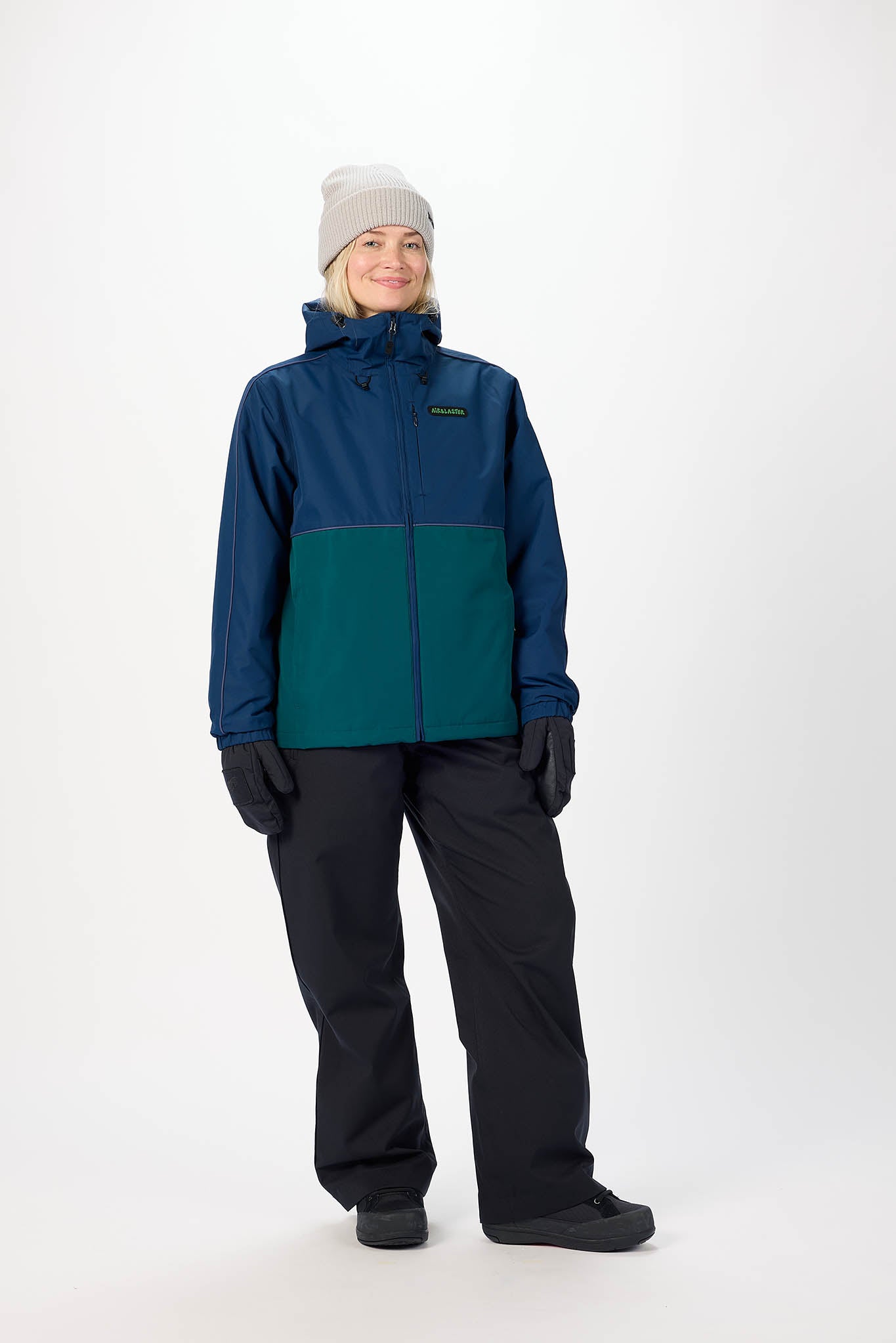 Person wearing a blue and green jacket with black pants on a white background