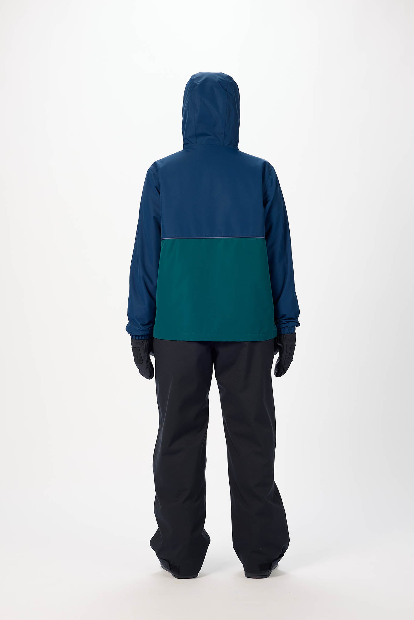 Person wearing a two-tone jacket with blue upper half and green lower half, standing against a white background.