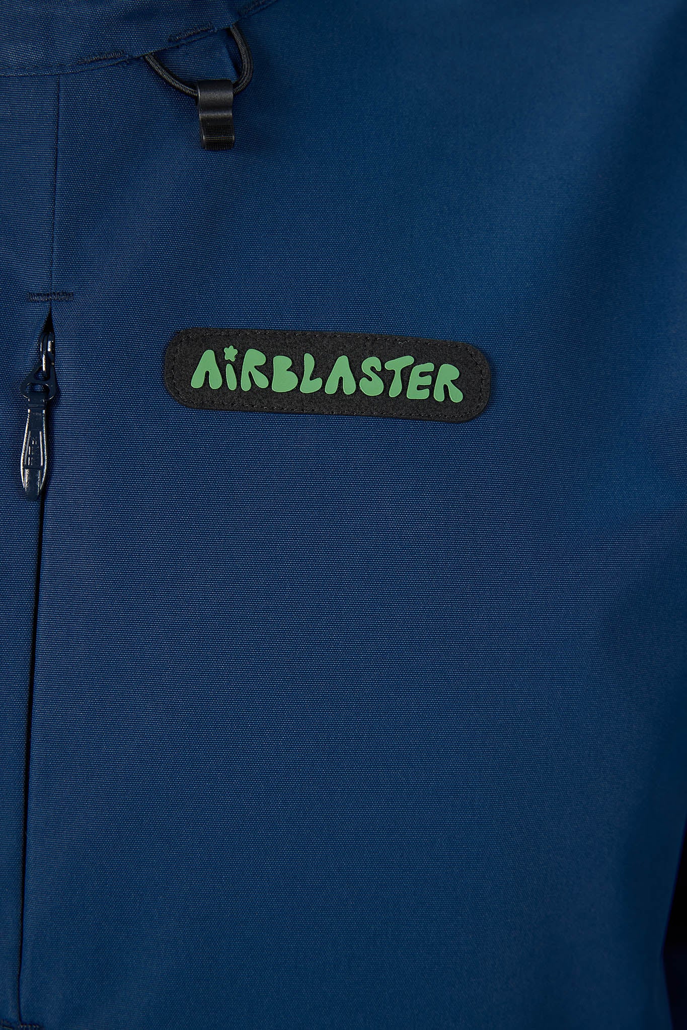 Close-up of a blue jacket with an 'Airblaster' logo on a dark background