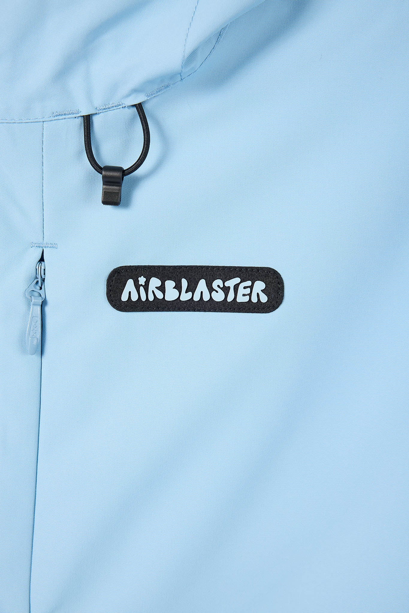 Light blue jacket with 'Airblaster' logo on a close-up of the fabric.