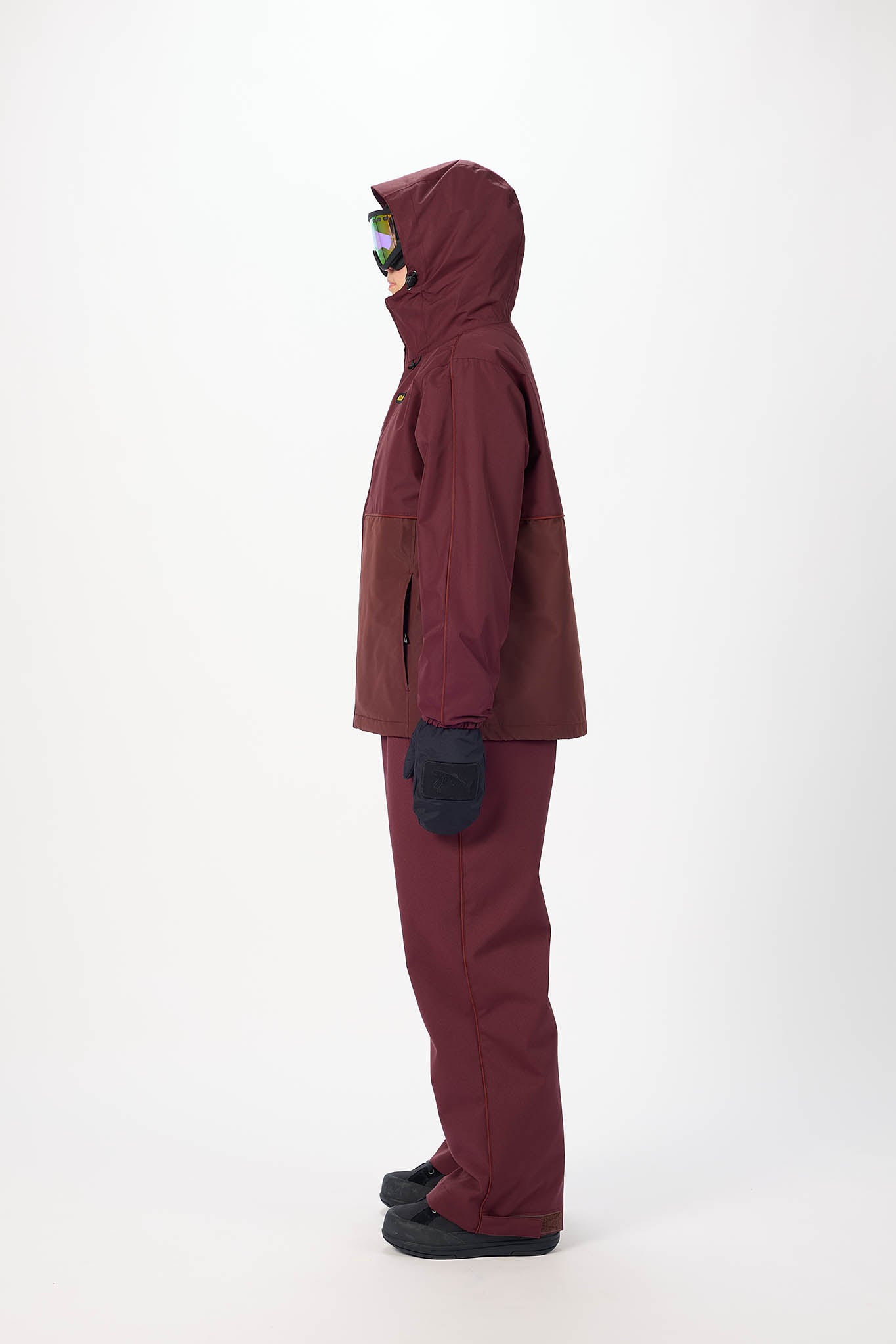 Person wearing a maroon snowsuit on a white background