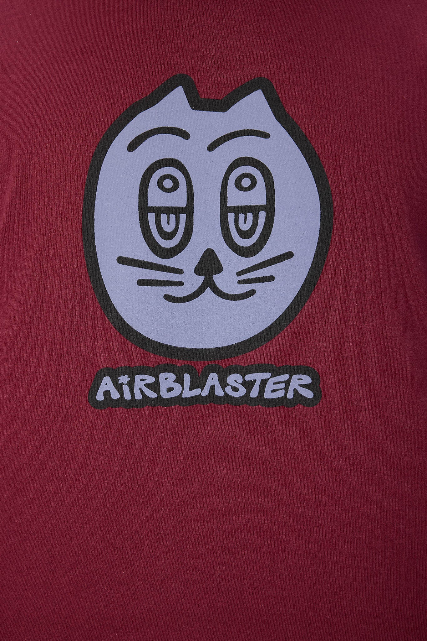 A close-up of a maroon garment featuring a pink graphic of a cat-like face with the word 'AIRBLASTER' underneath.