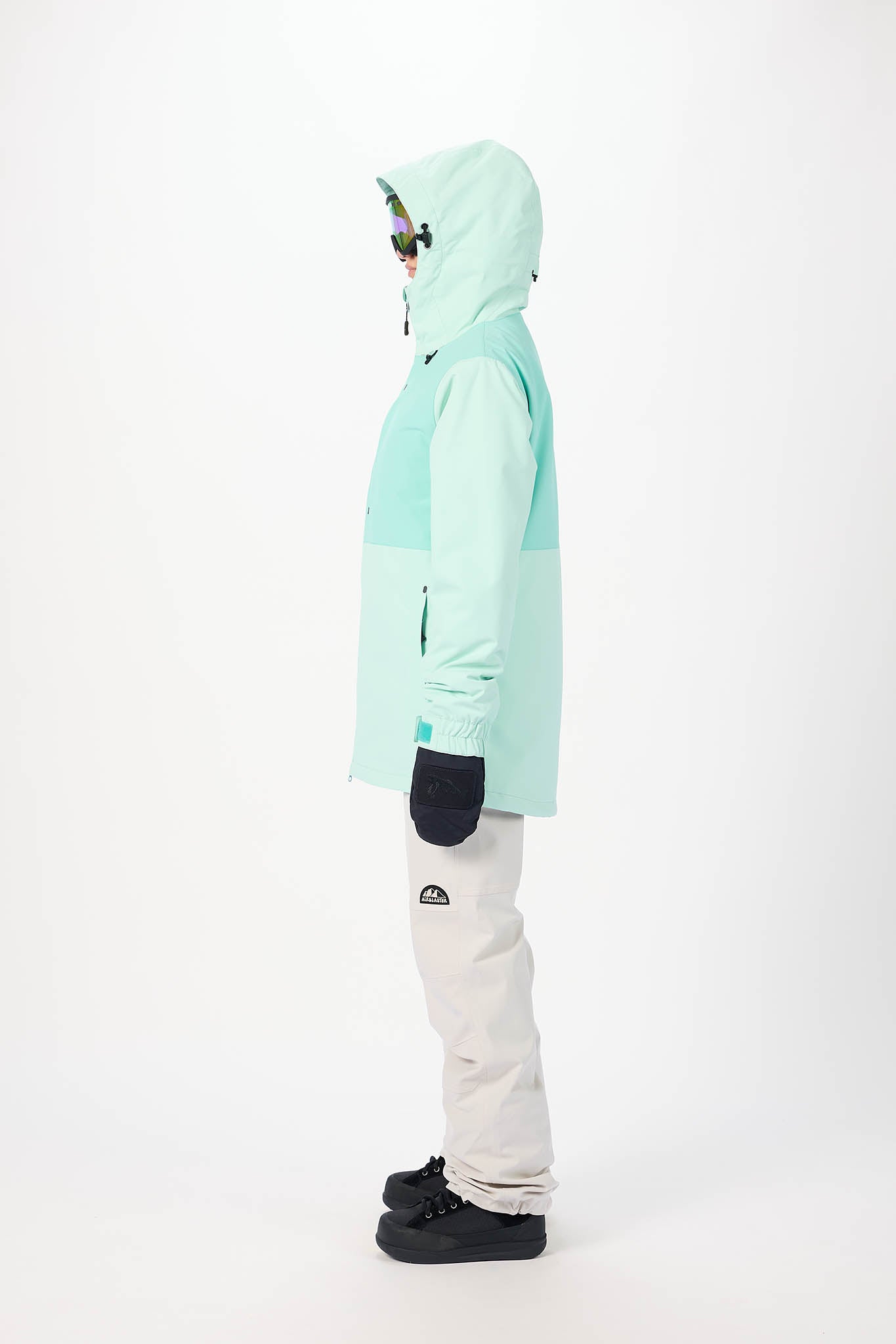 Person wearing a light blue jacket and white pants on a white background