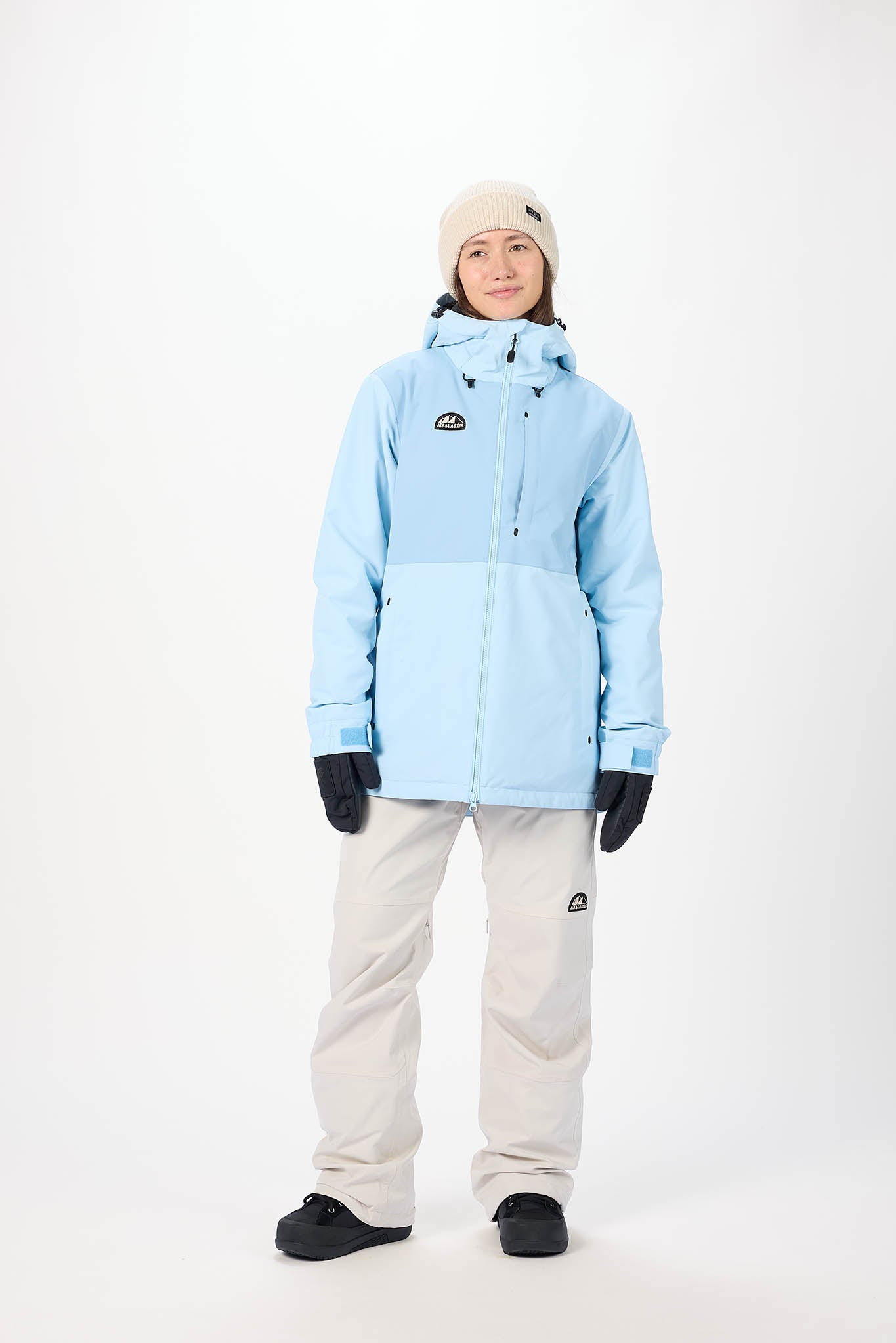 Person wearing a light blue jacket and white pants on a white background