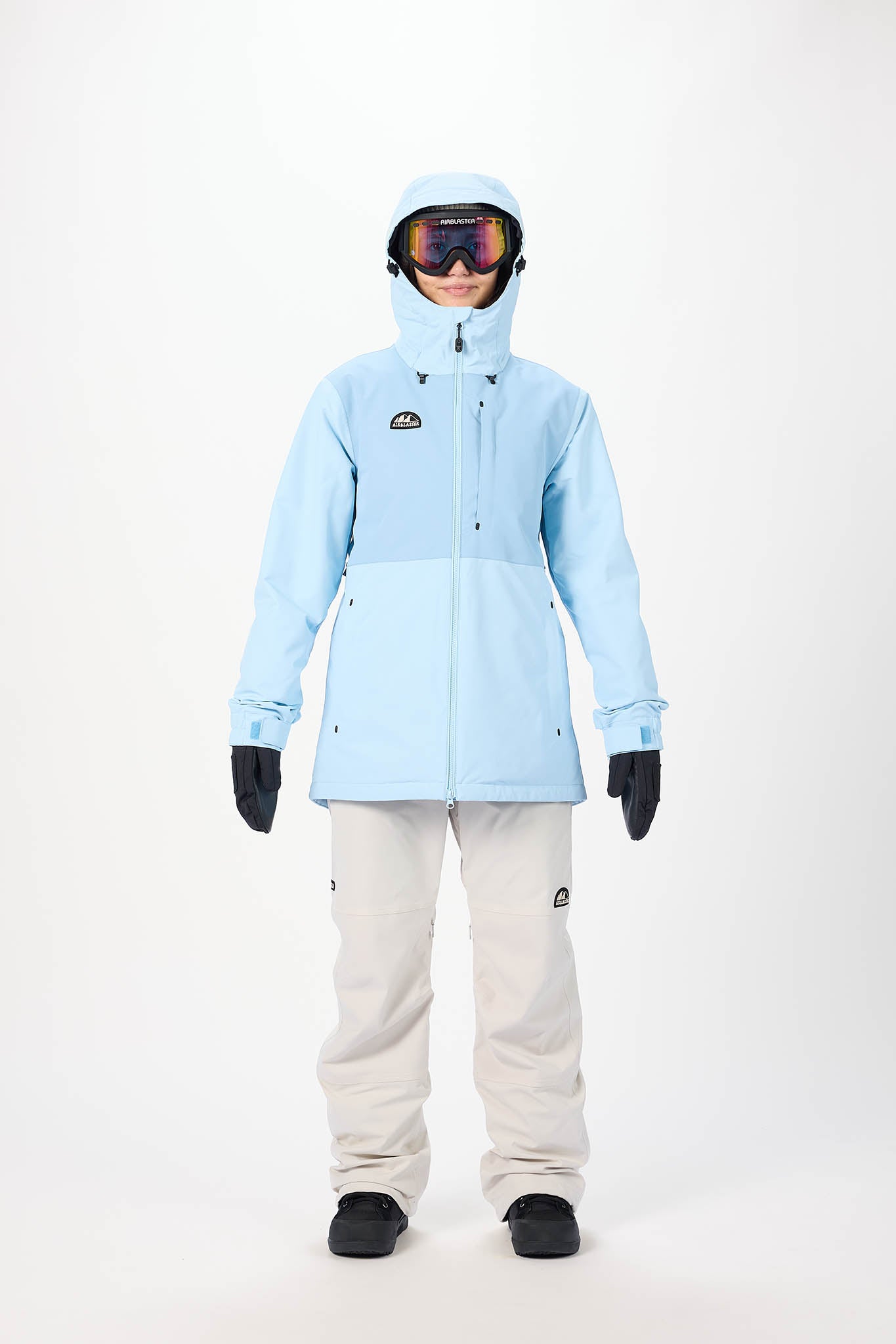 Person wearing a light blue snow jacket and white pants on a white background