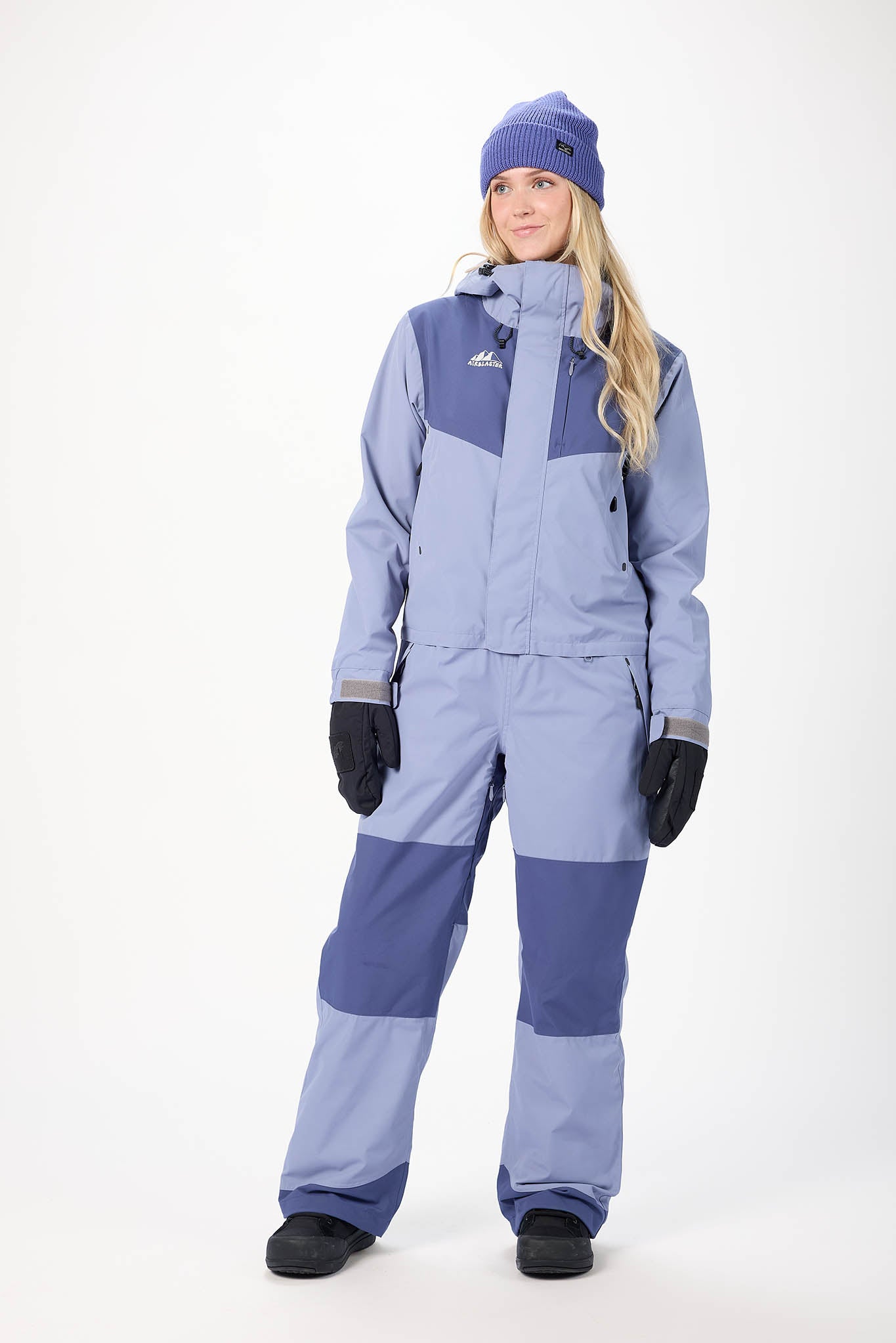 Person wearing a blue and gray snowsuit with matching hat and gloves on a white background