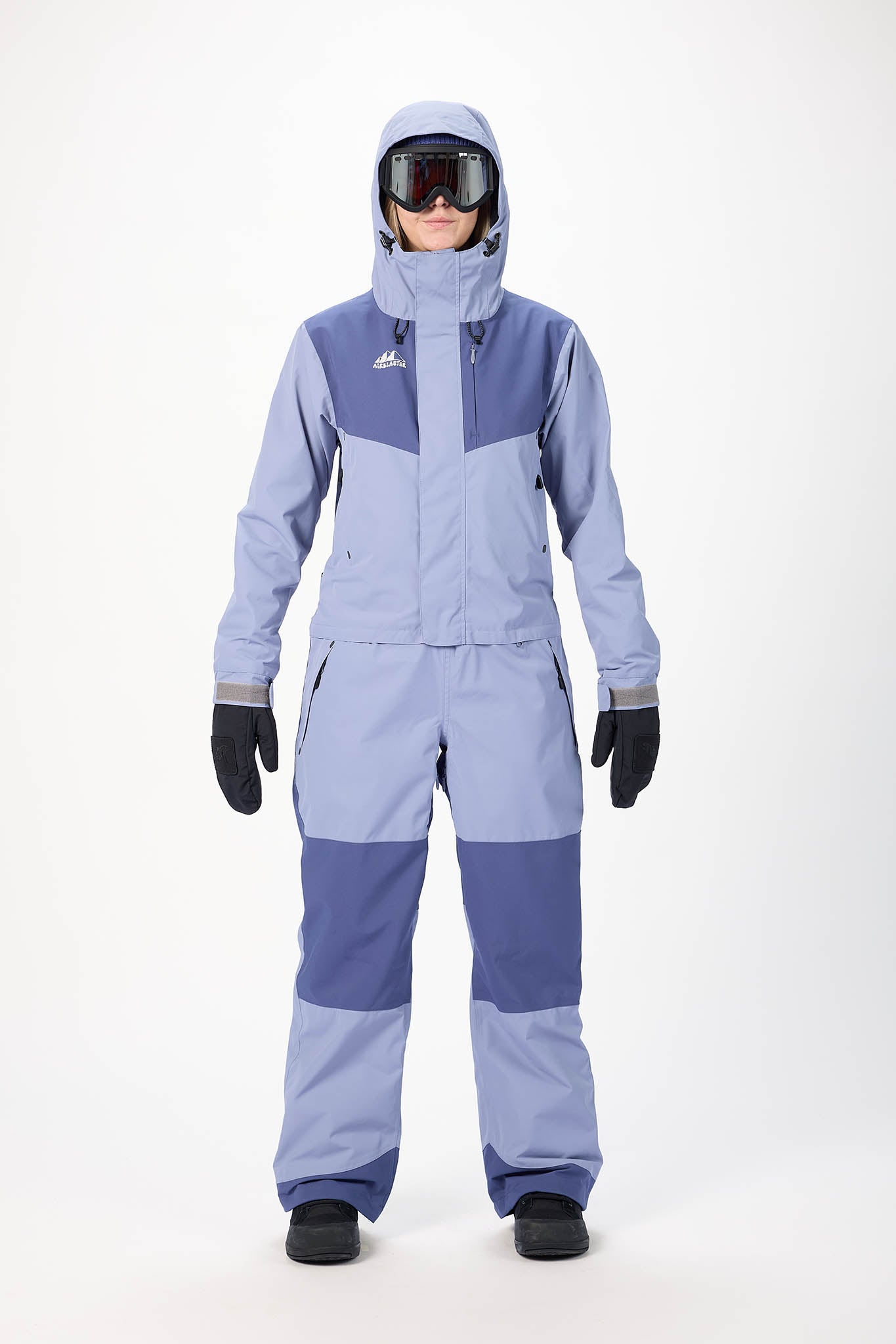 Person wearing a two-tone blue snowsuit with a white background