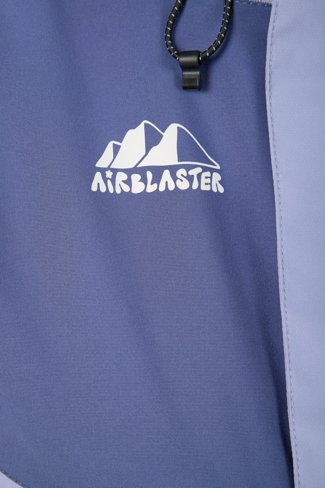 Close-up of a blue jacket with 'Airblaster' logo featuring mountain design.
