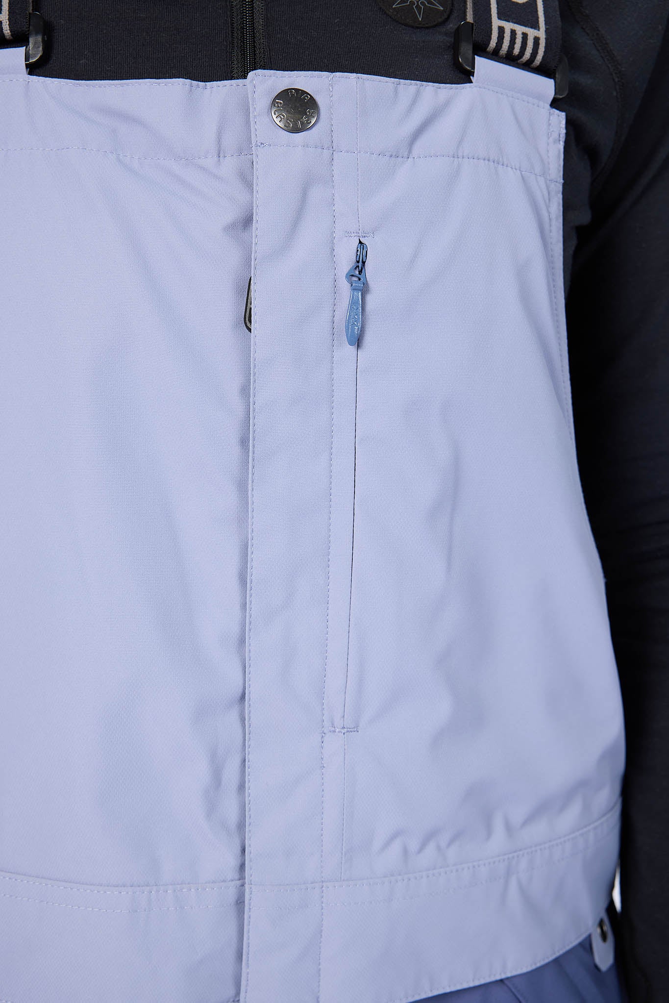Light blue vest with a zipper and button details, worn by a person.
