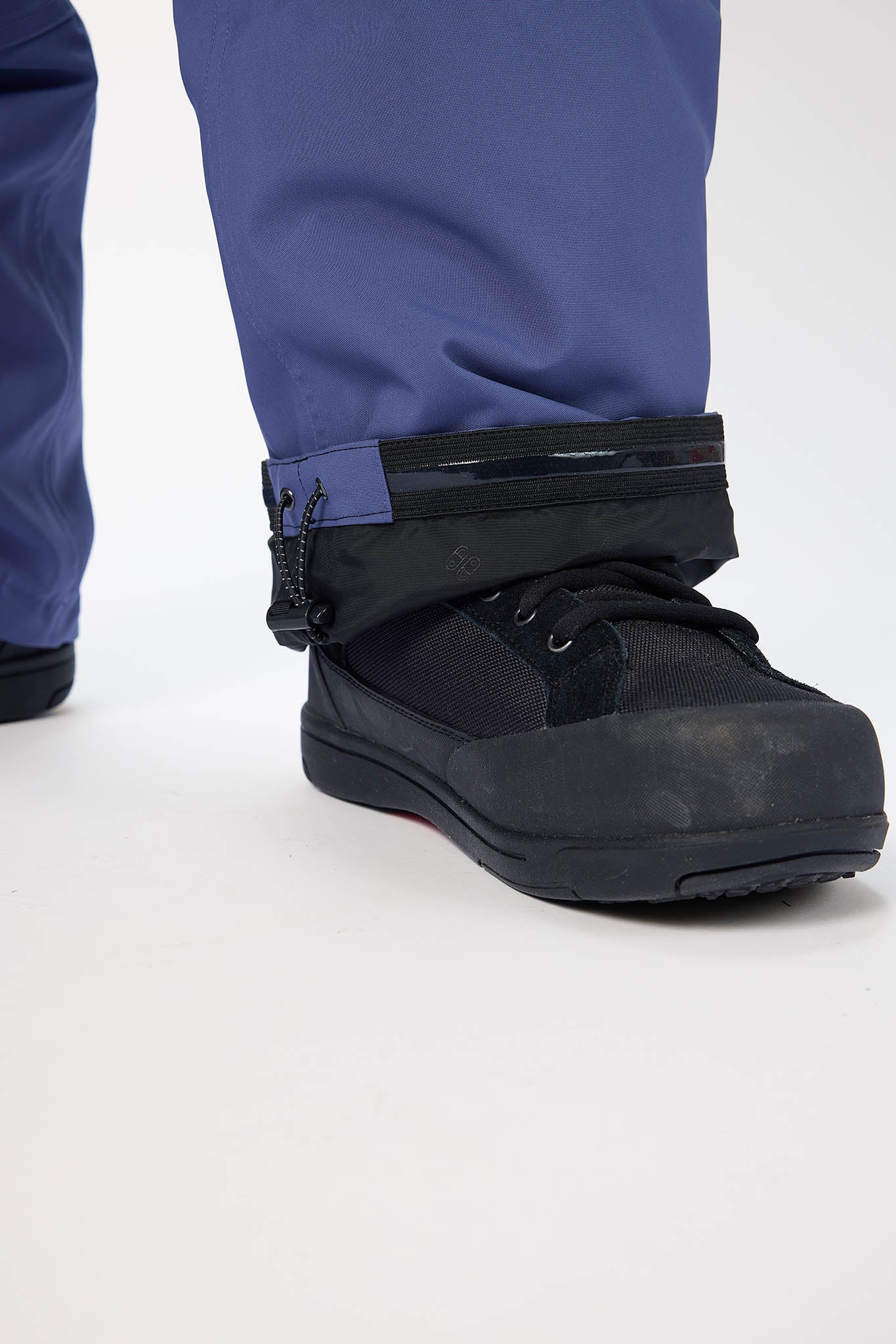 Black boot with blue pants on a white background