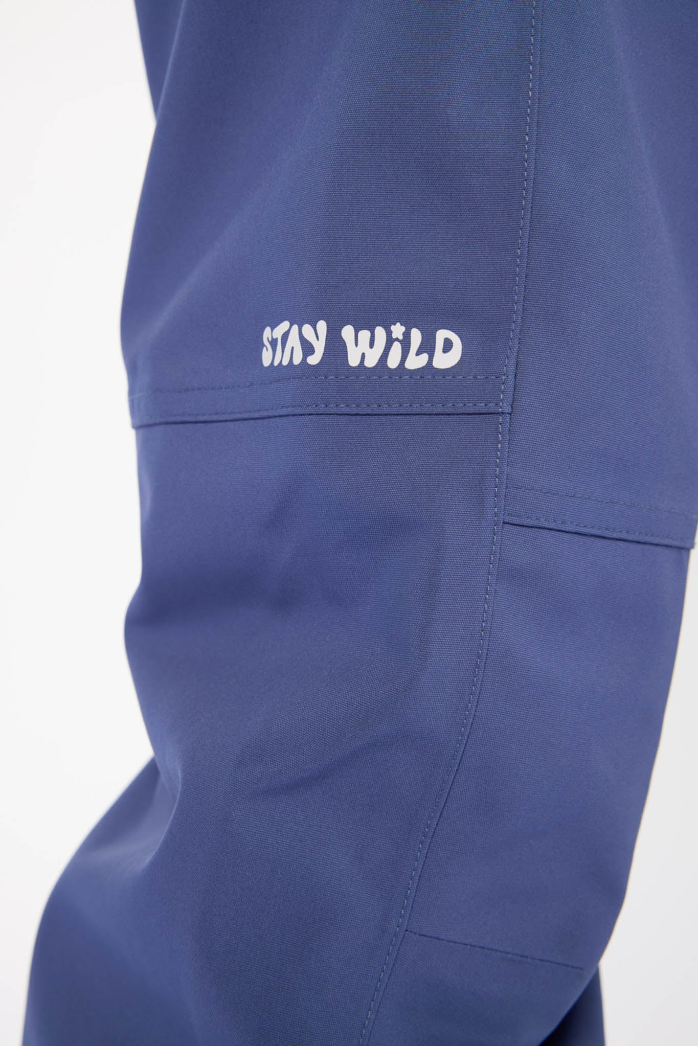 Blue pants with 'Stay Wild' text on a white background