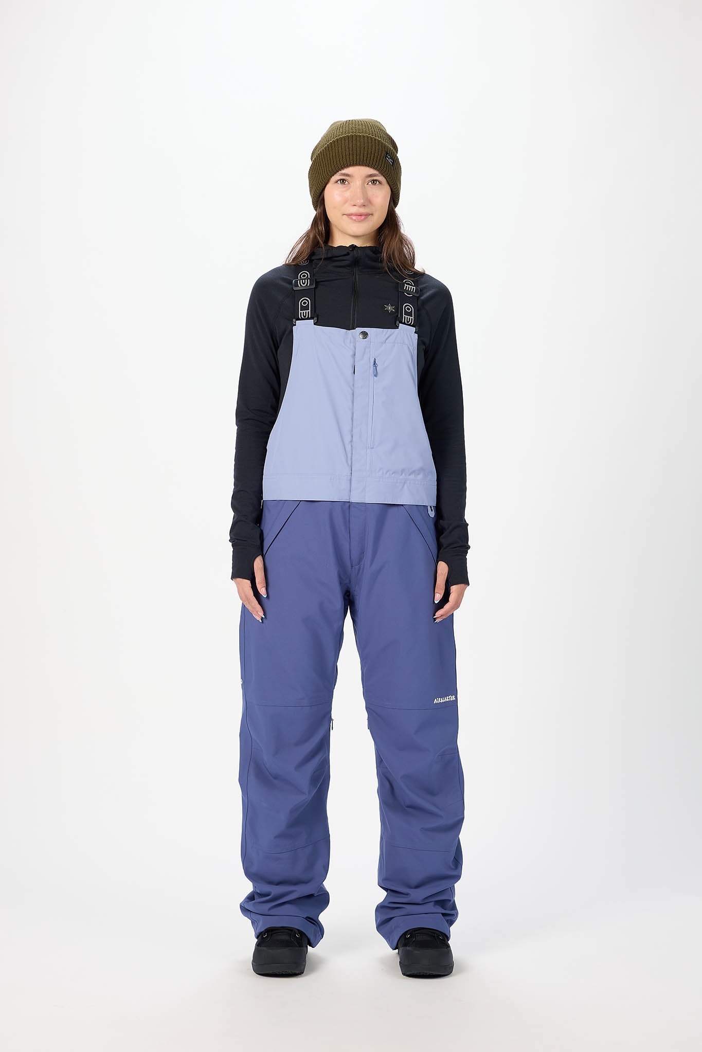 Person wearing a black and blue snowsuit with a white background
