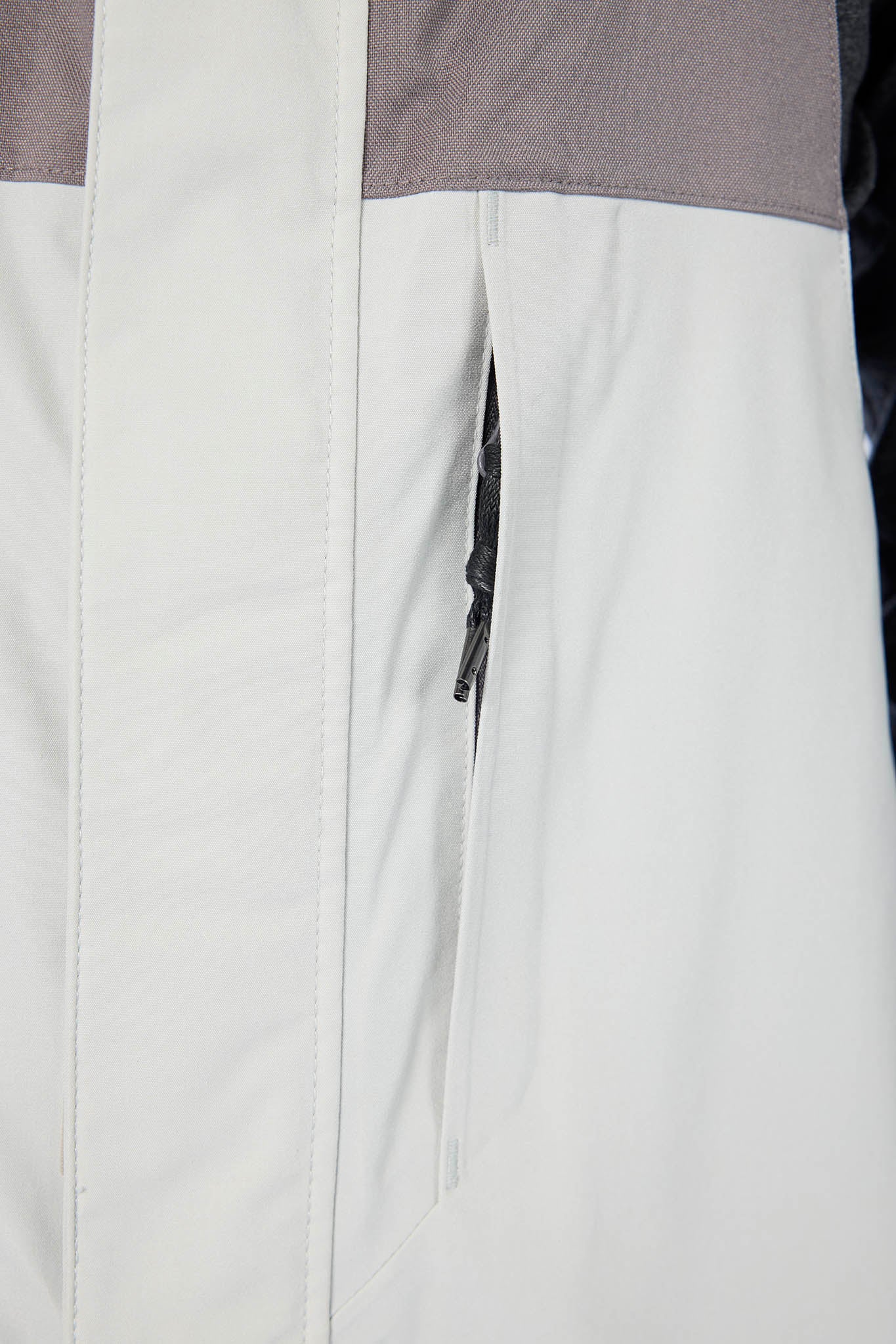 Close-up of a gray and white jacket with a zipper detail.