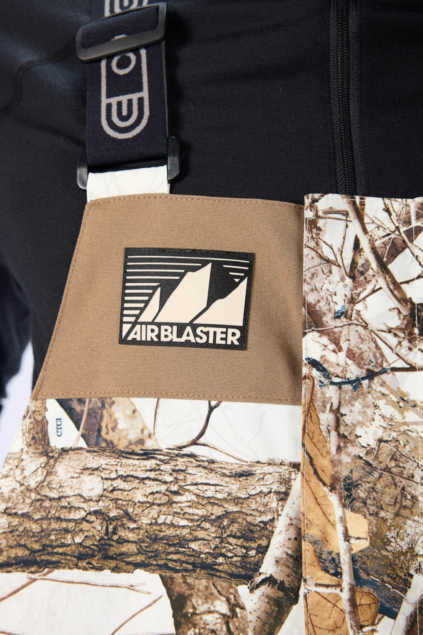 Airblaster logo on a brown pouch with a camouflage pattern in the background
