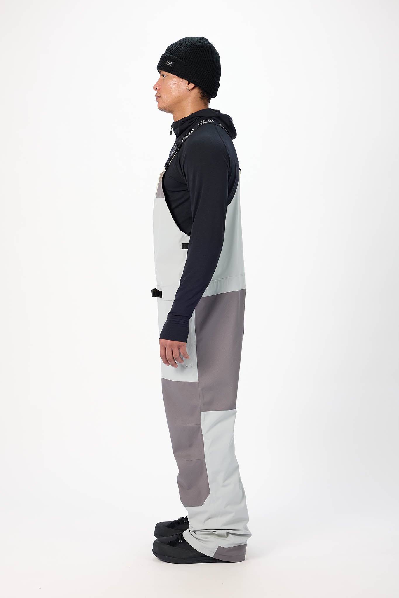 Person wearing a black and gray snowsuit on a white background