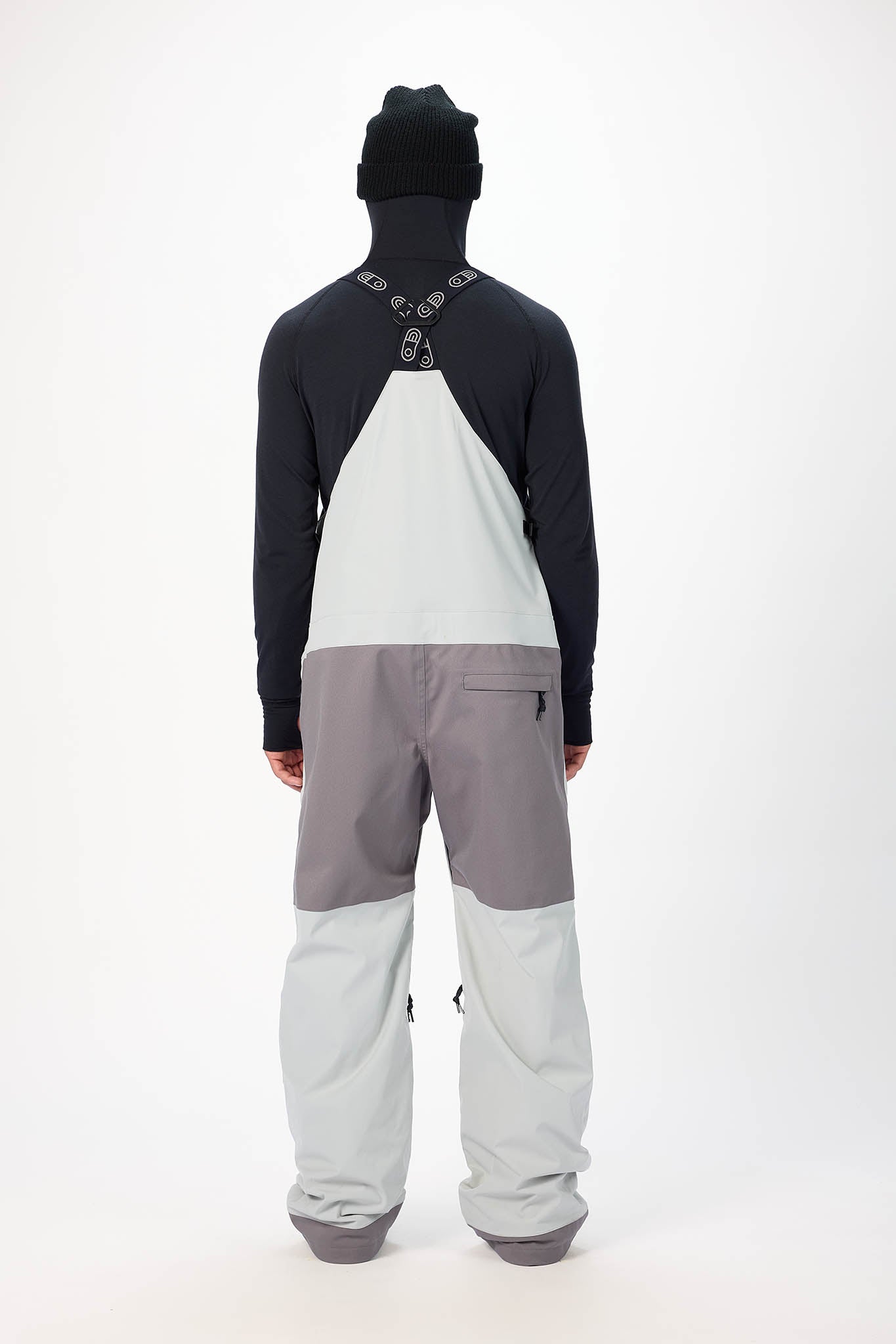 Person wearing a black and gray snowsuit on a white background