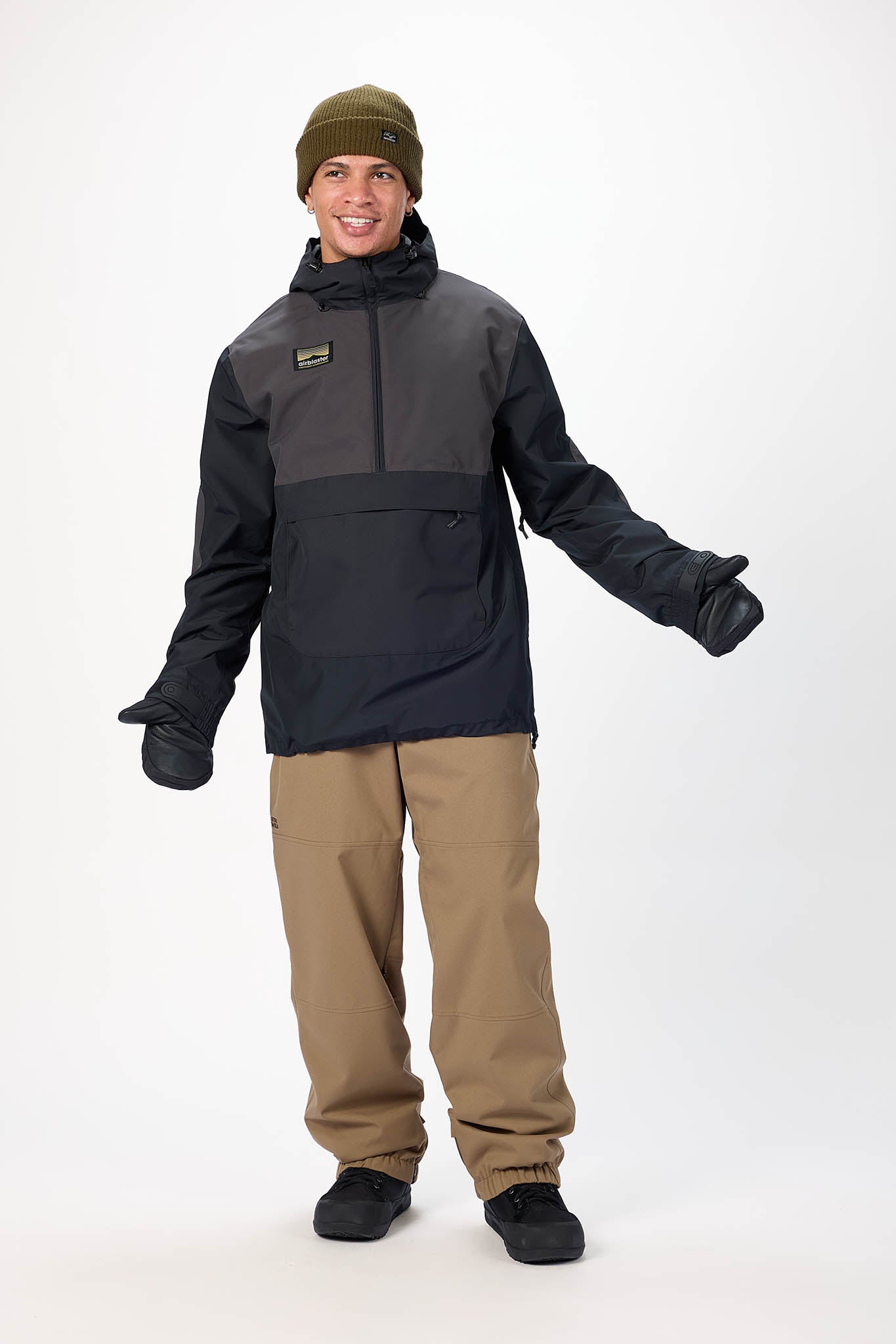 Person wearing a black jacket, beige pants, and a green beanie on a white background