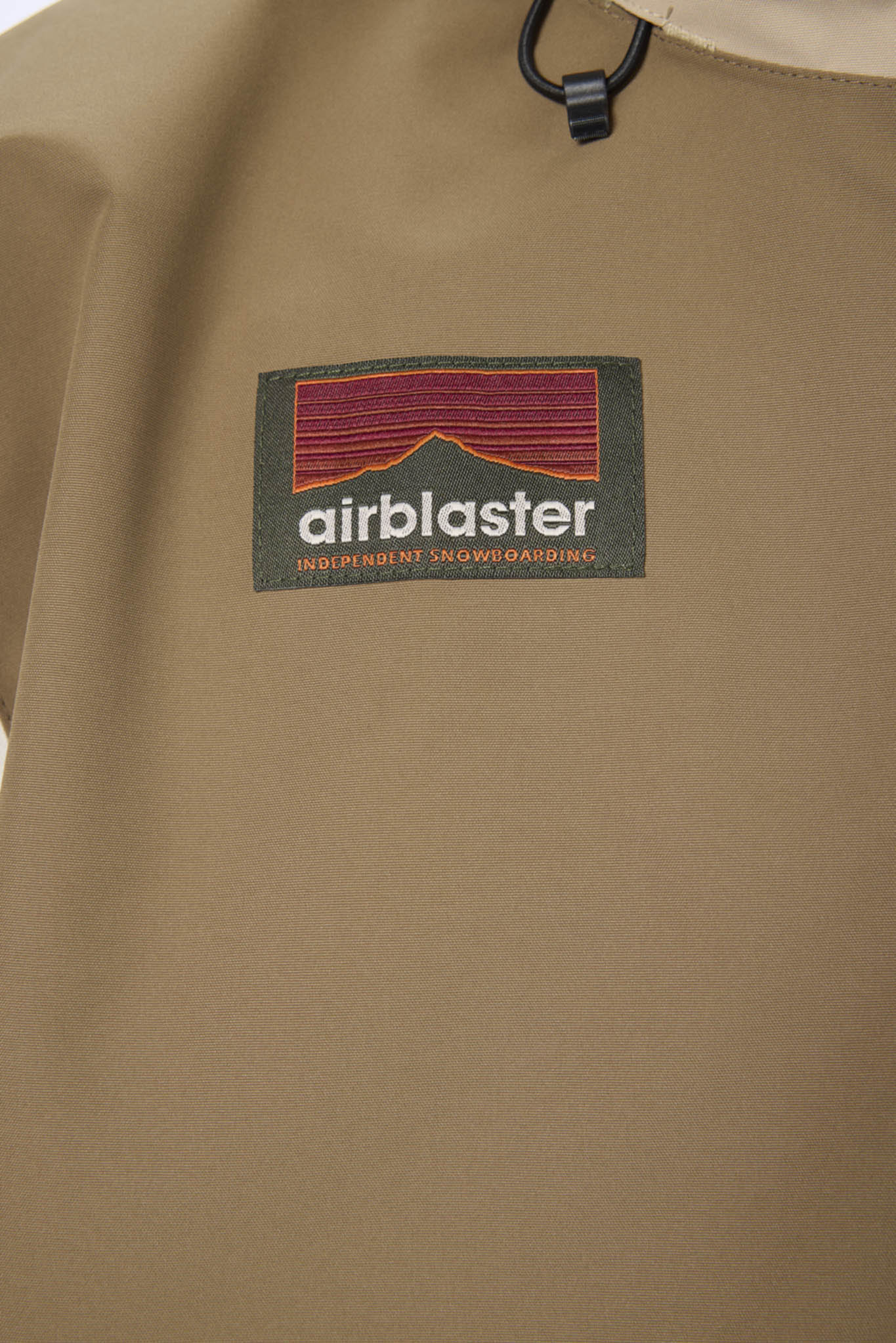 Brown jacket with Airblaster logo on a beige background