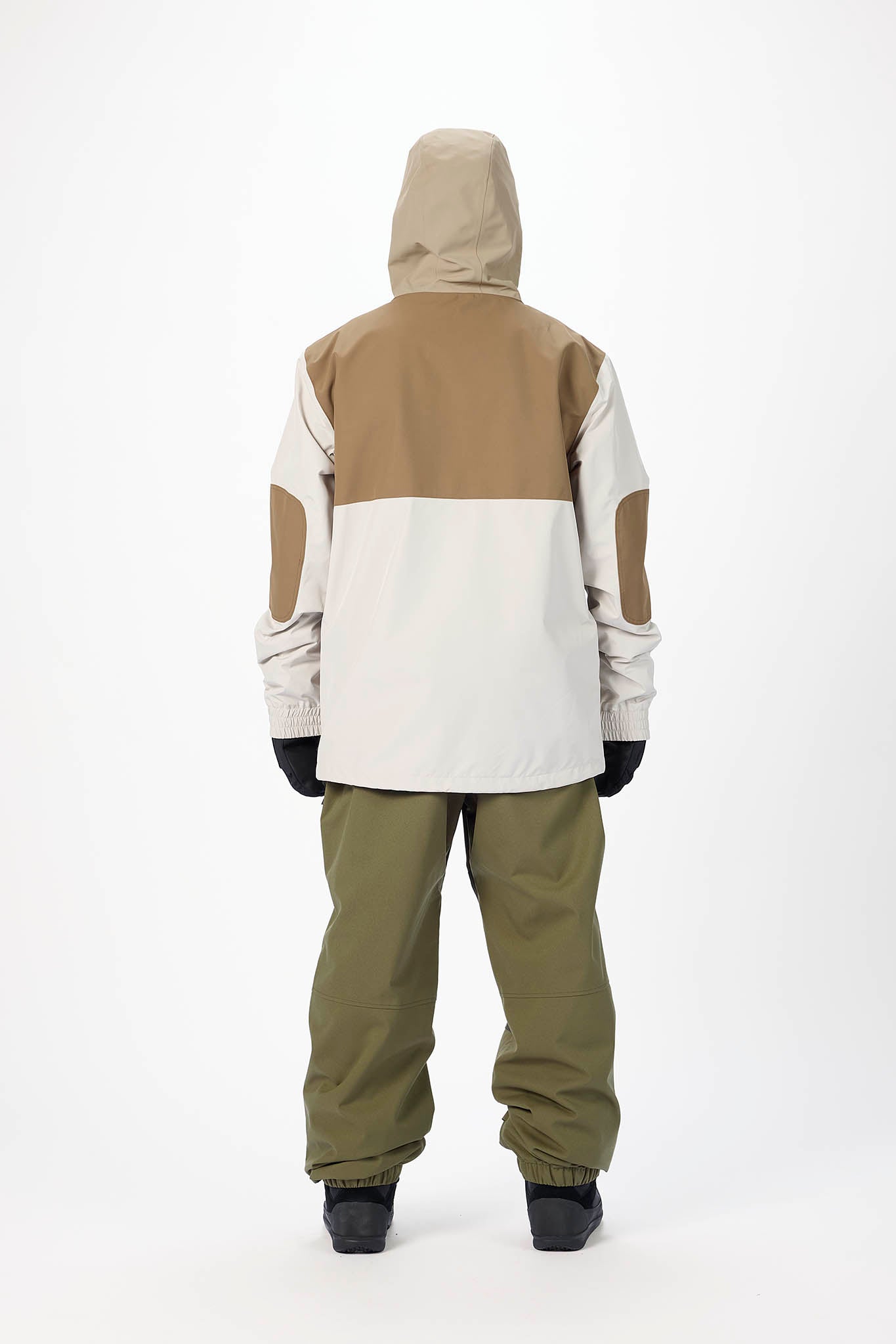 Person wearing a two-tone snowboarding jacket and pants on a white background