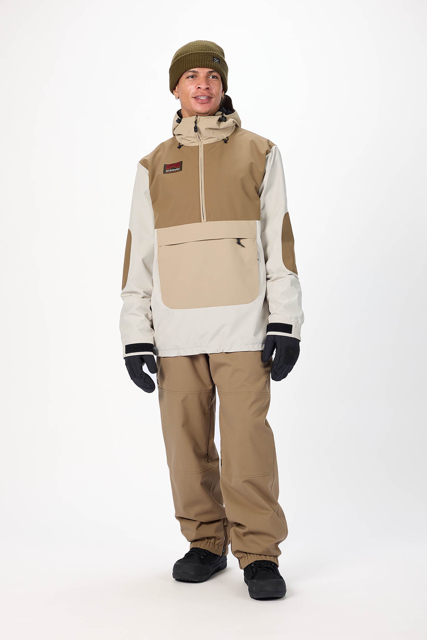 Person wearing a beige and white snowsuit with a beanie on a white background