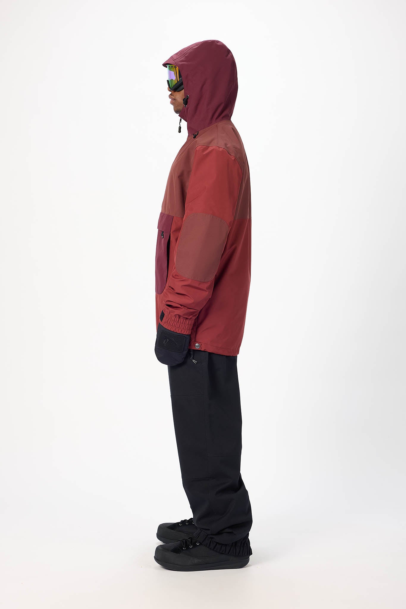 Person wearing a red and black snowsuit on a white background