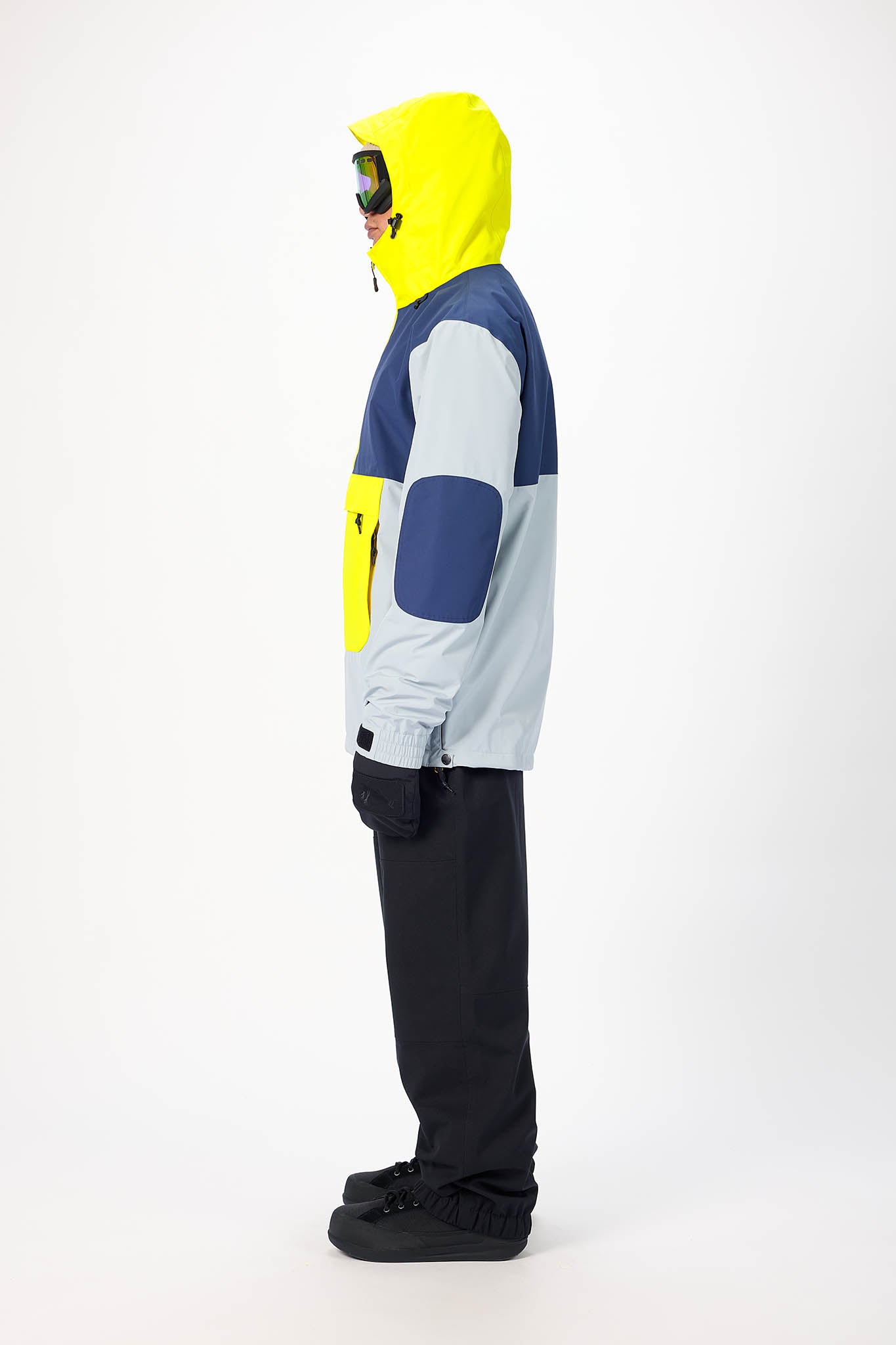 Person wearing a colorful snowboarding outfit with a yellow hood on a white background