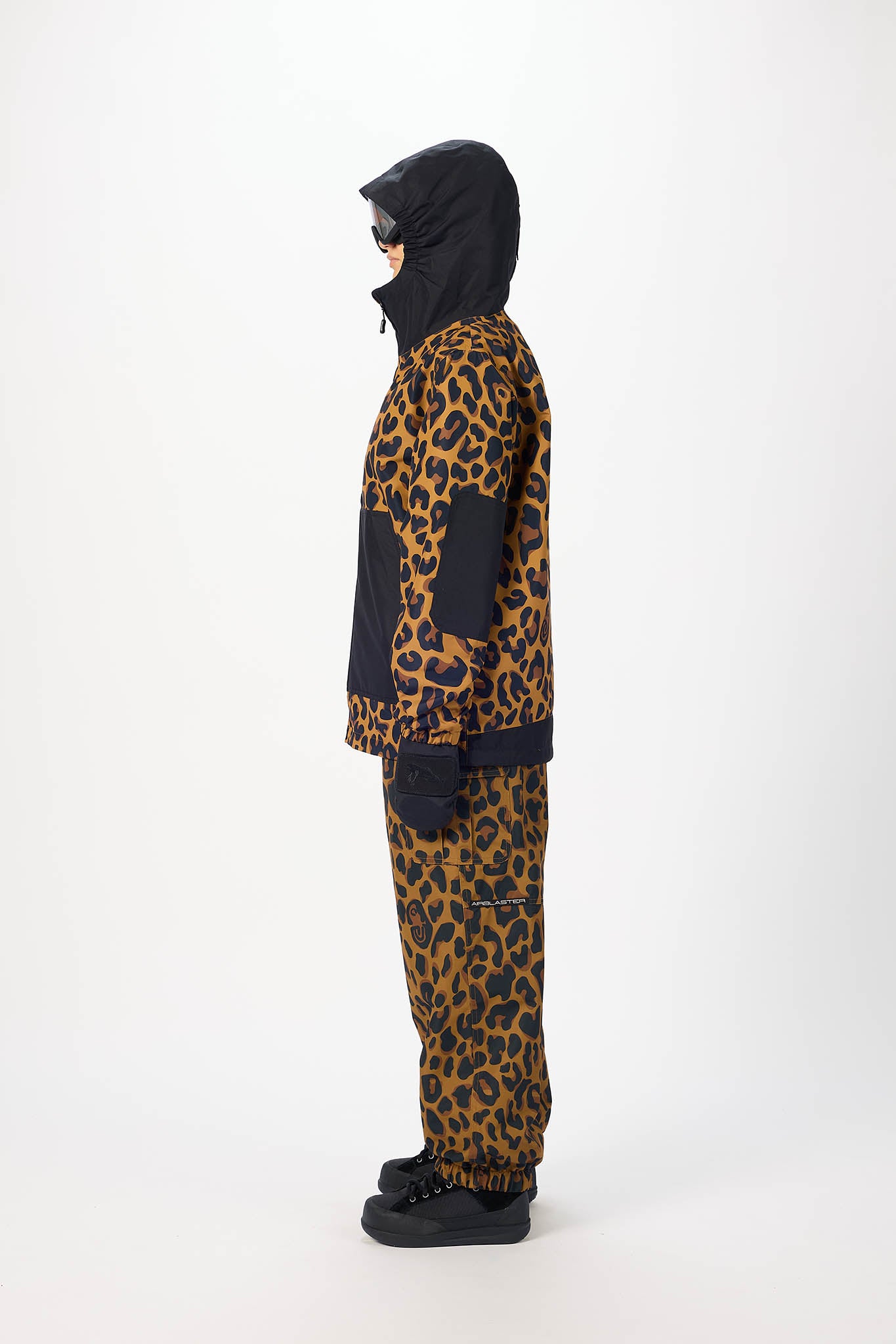 Person wearing a leopard print outfit with a black hood on a white background