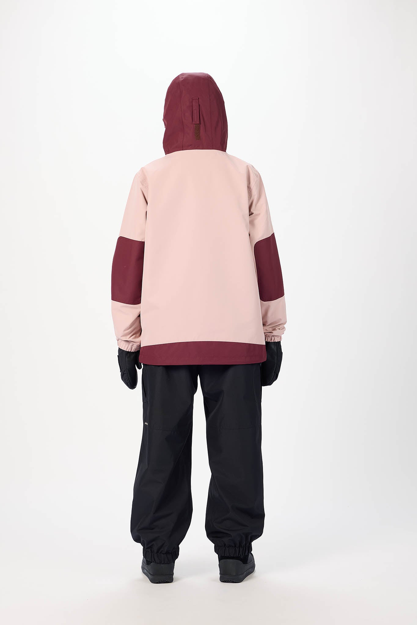 Person wearing a two-tone pink and maroon hoodie with black pants on a white background