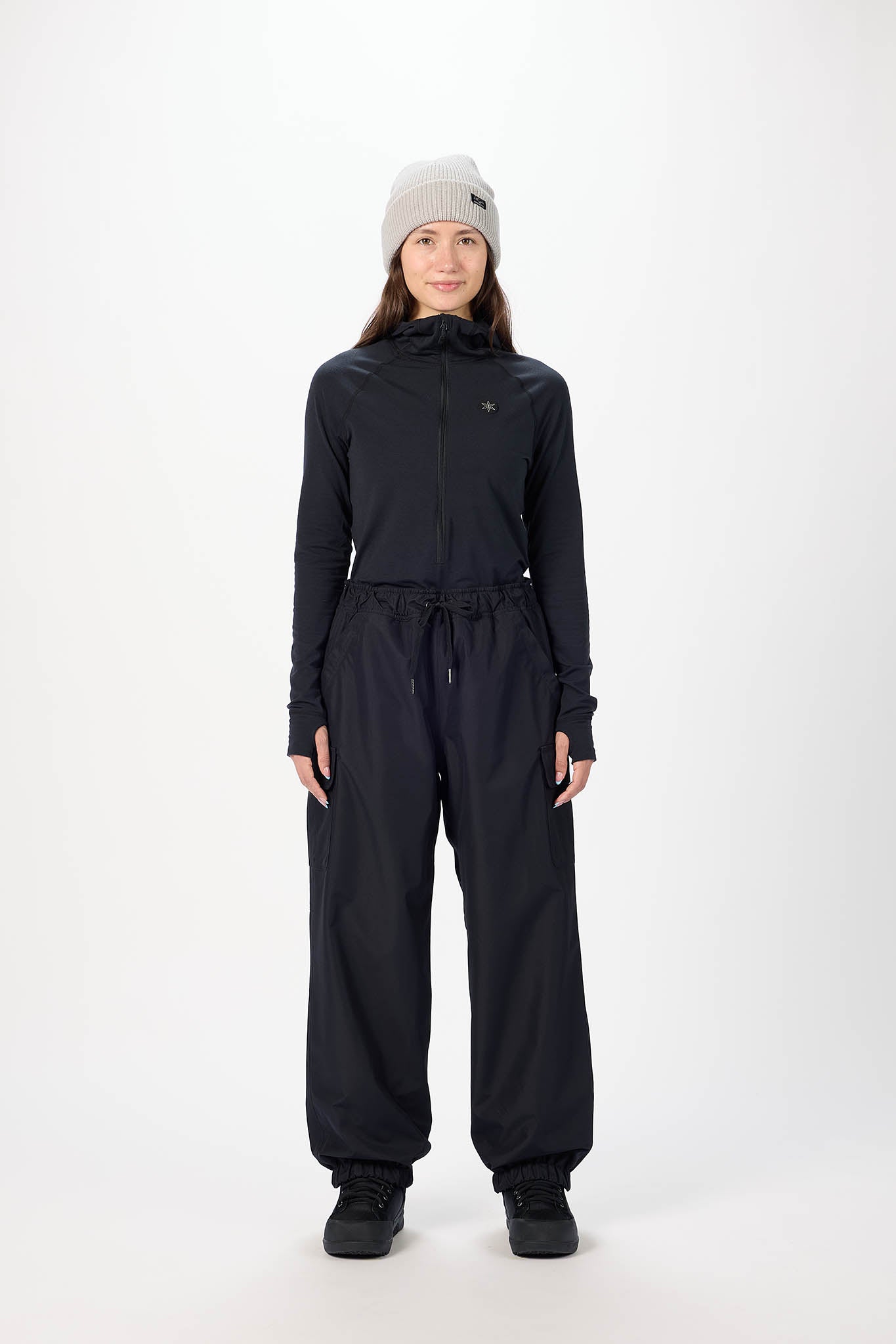 Person wearing a black outfit with a hood on a white background