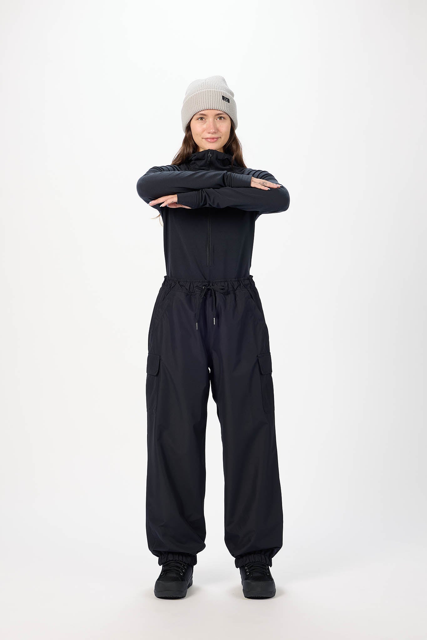 Person wearing a black snowsuit and gray beanie on a white background