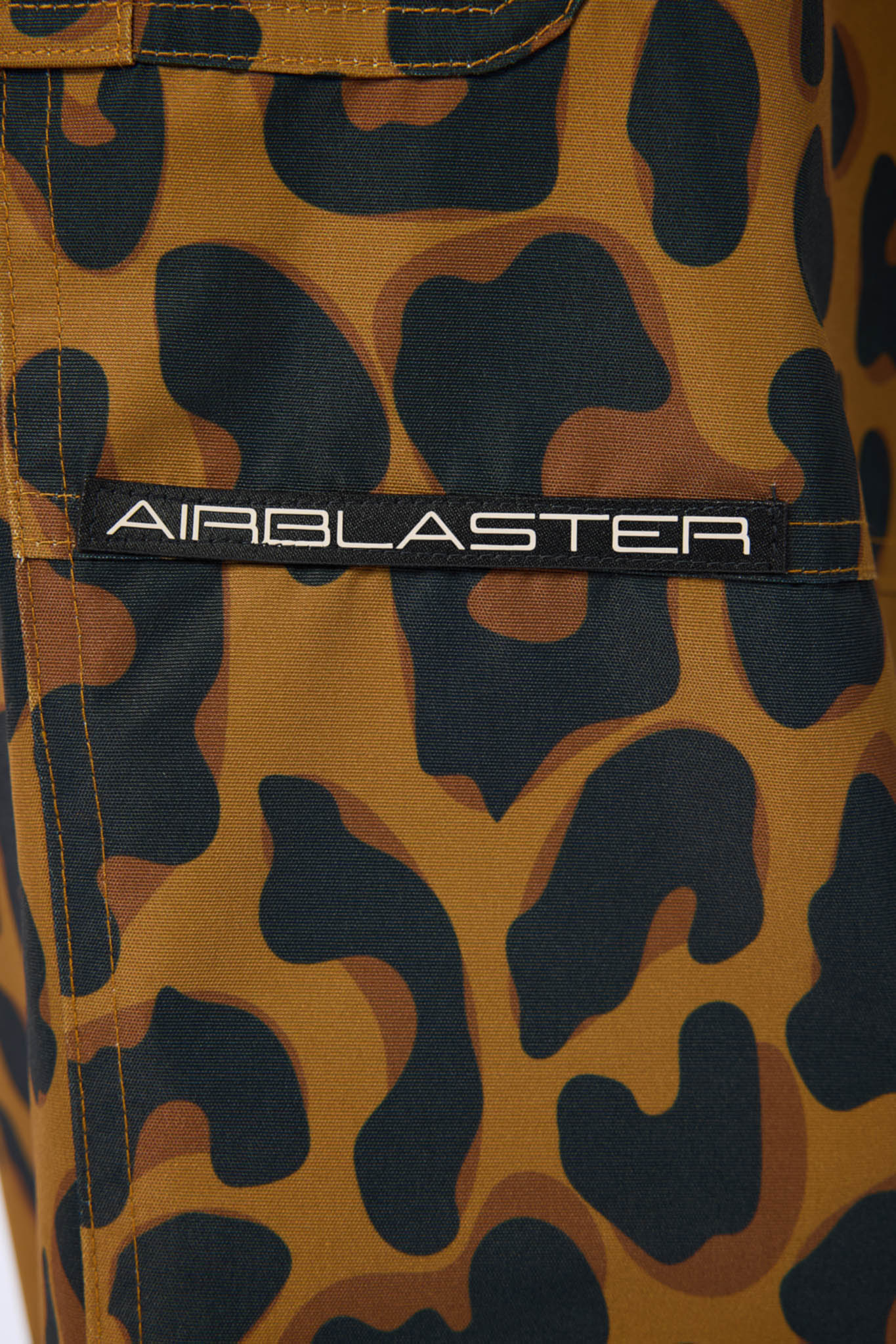 Camouflage pants with 'Airblaster' logo on a close-up view