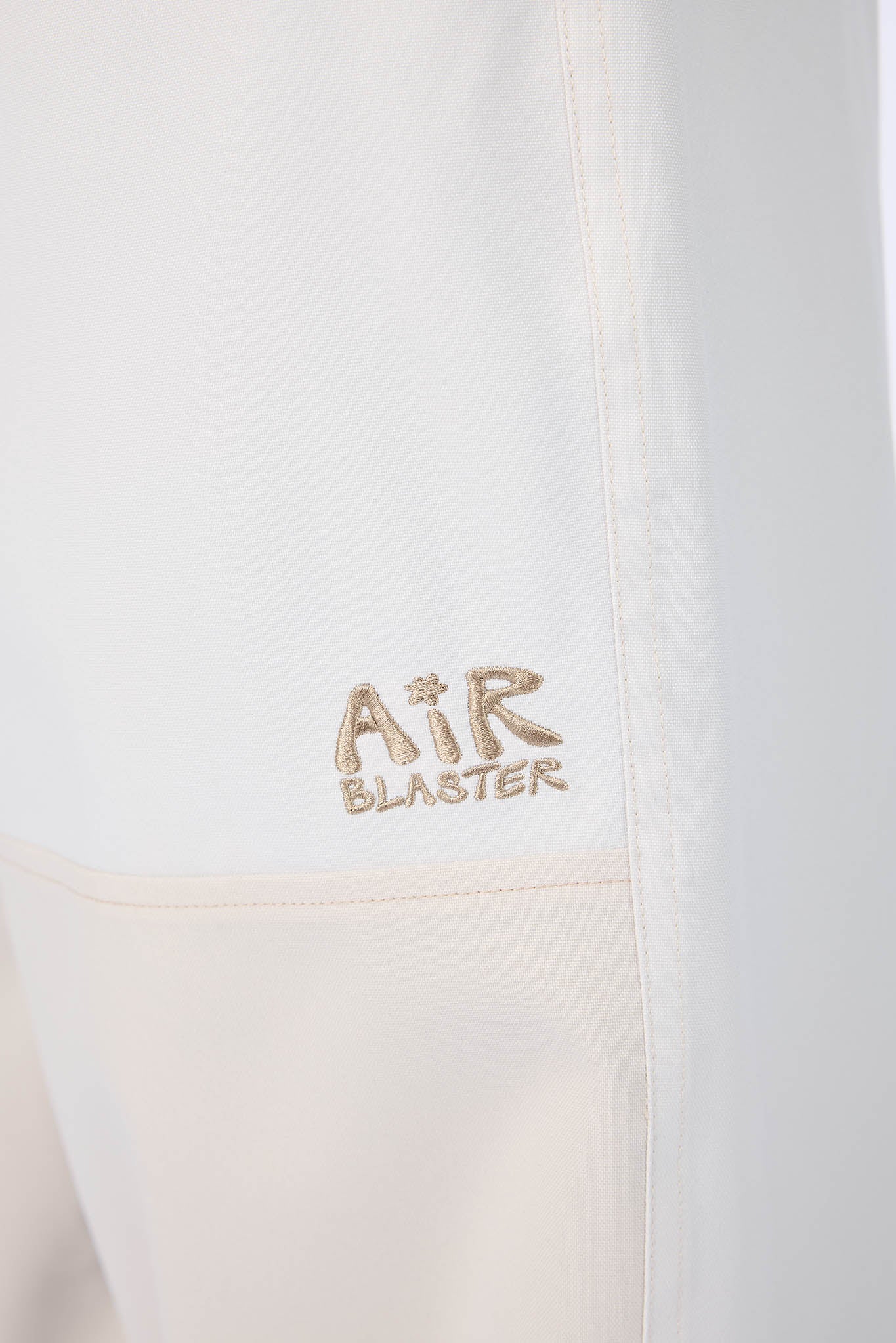 Close-up of a white jacket with 'Air Blaster' branding on a white background