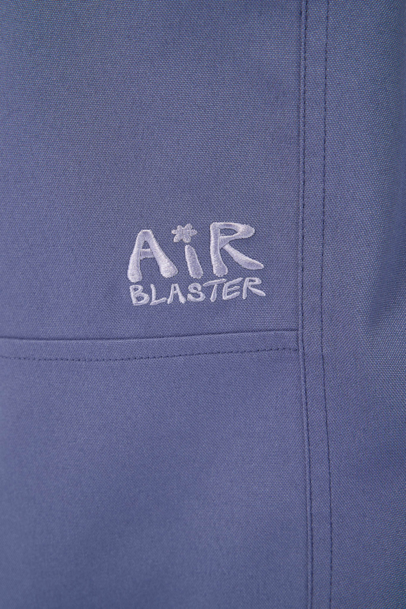 Close-up of a blue jacket with 'Air Blaster' logo embroidered on it.