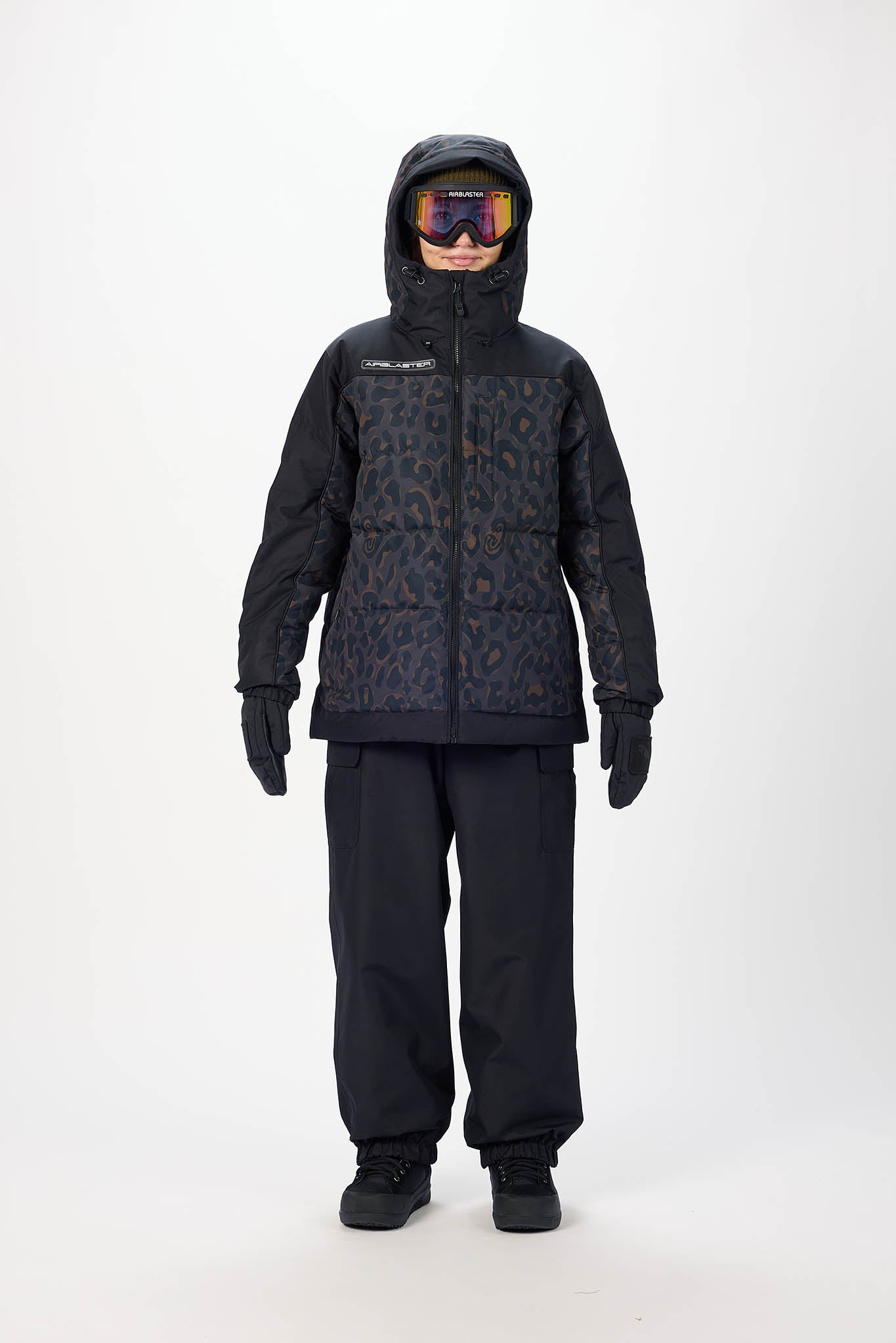 Person wearing a black snowsuit with a hood on a white background