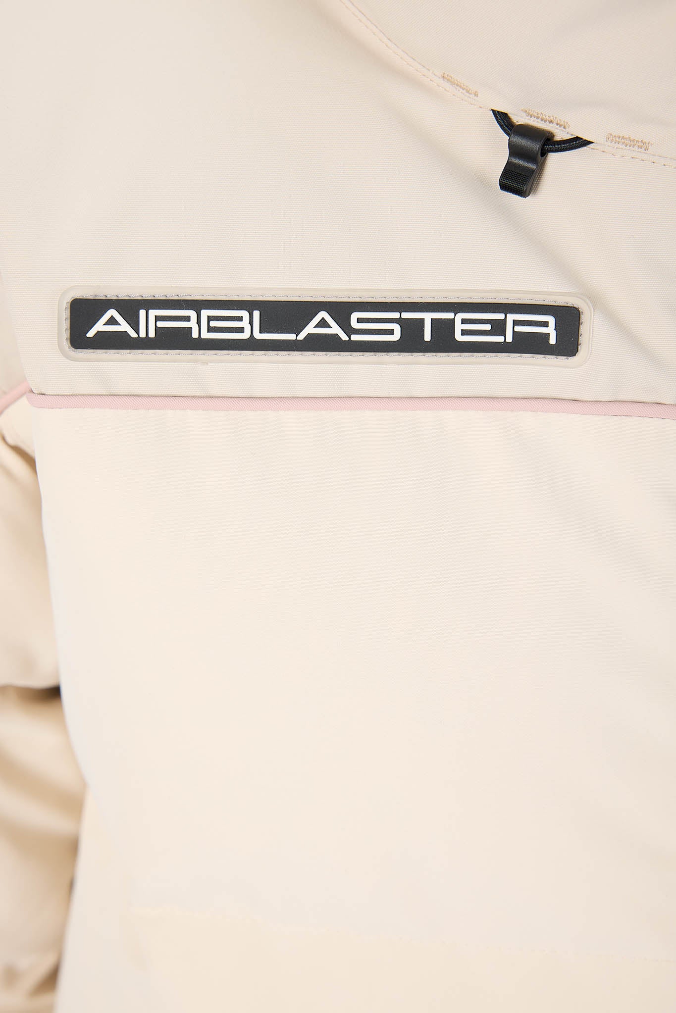 Beige jacket with 'AIRBLASTER' logo on a beige background