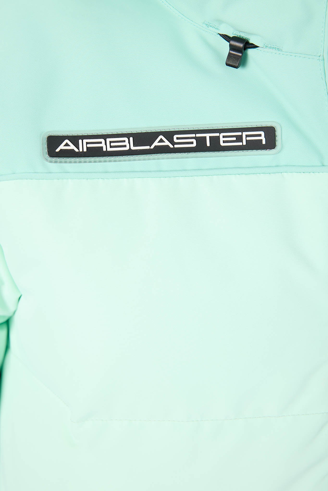 Close-up of a light green jacket with 'Airblaster' logo on a white background