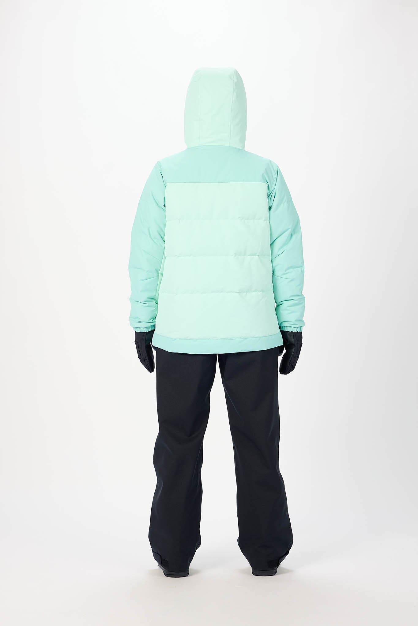 Person wearing a light blue jacket and black pants on a white background