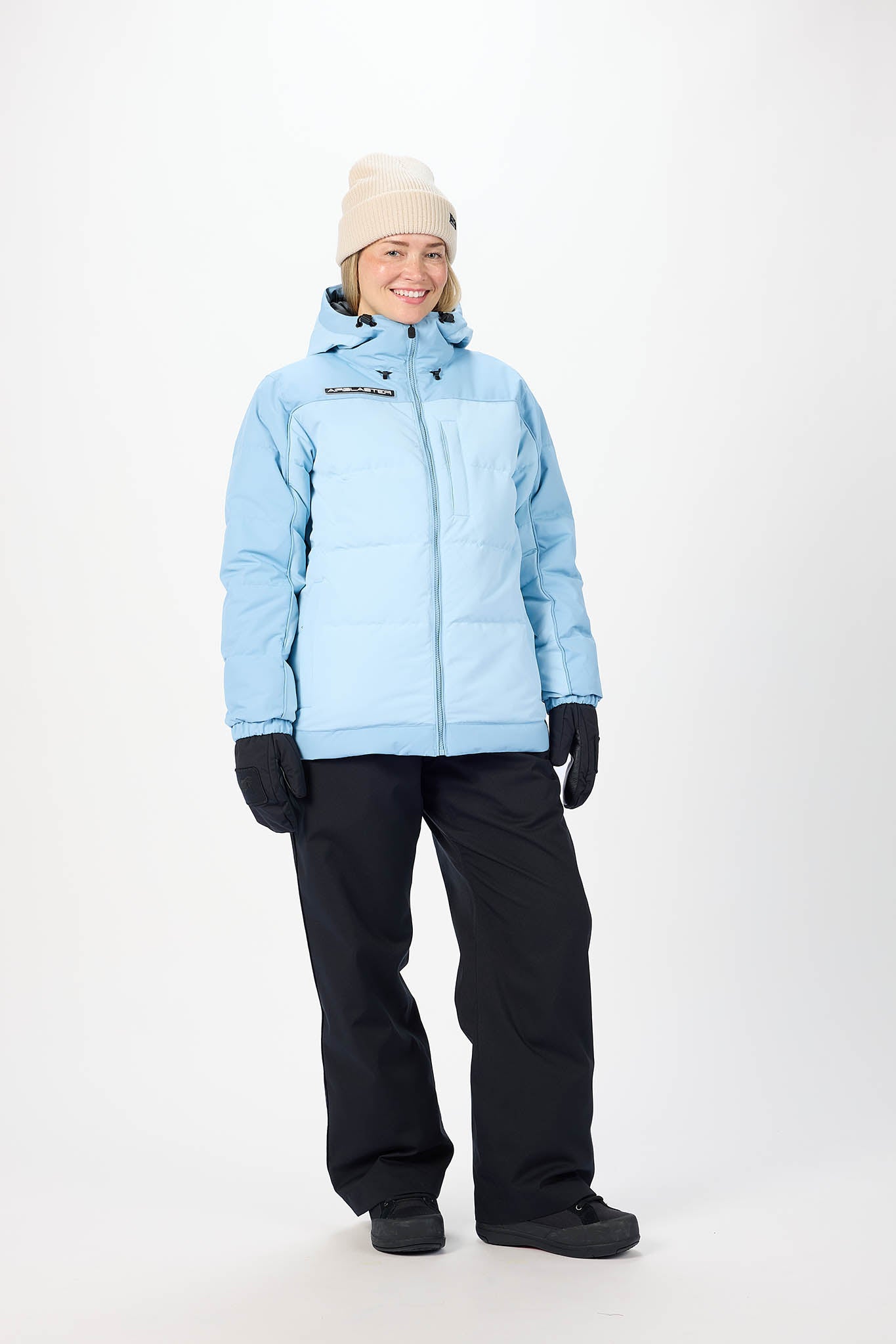 Person wearing a light blue winter jacket and black pants on a white background