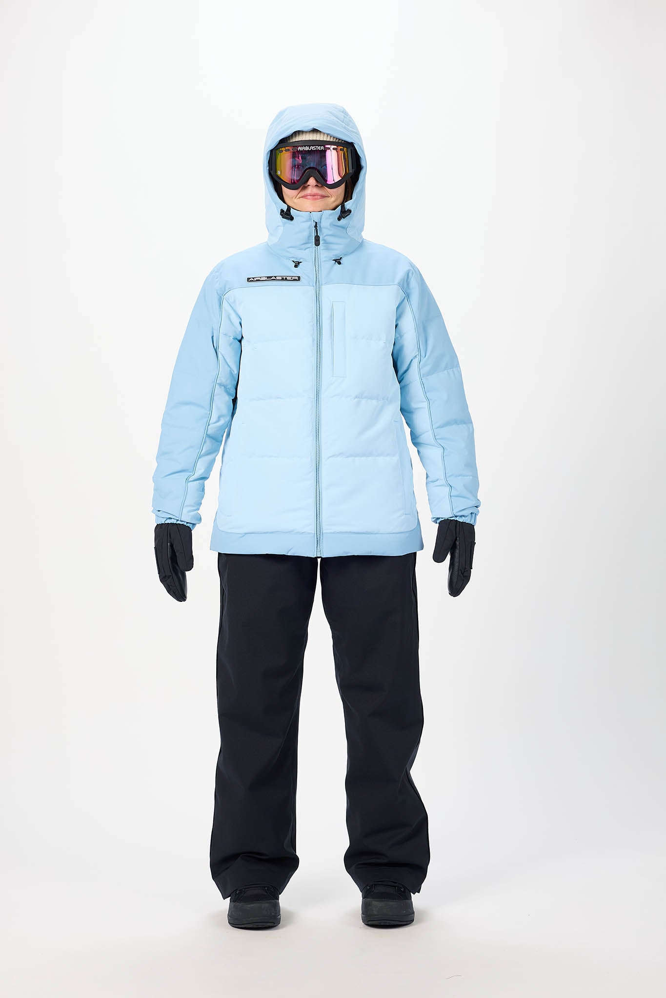 Person wearing a light blue winter jacket and black pants on a white background