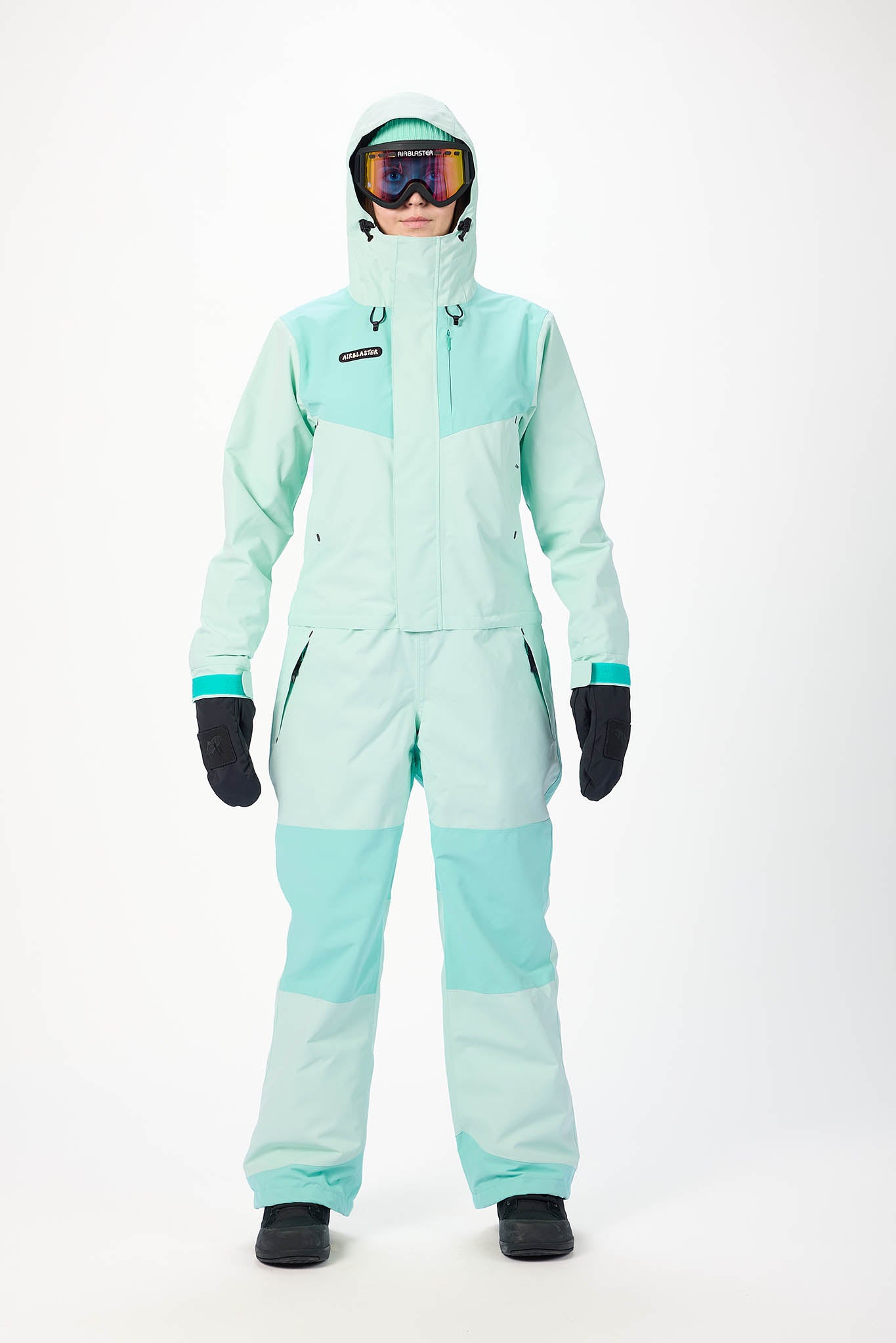 Person wearing a mint snowsuit on a white background