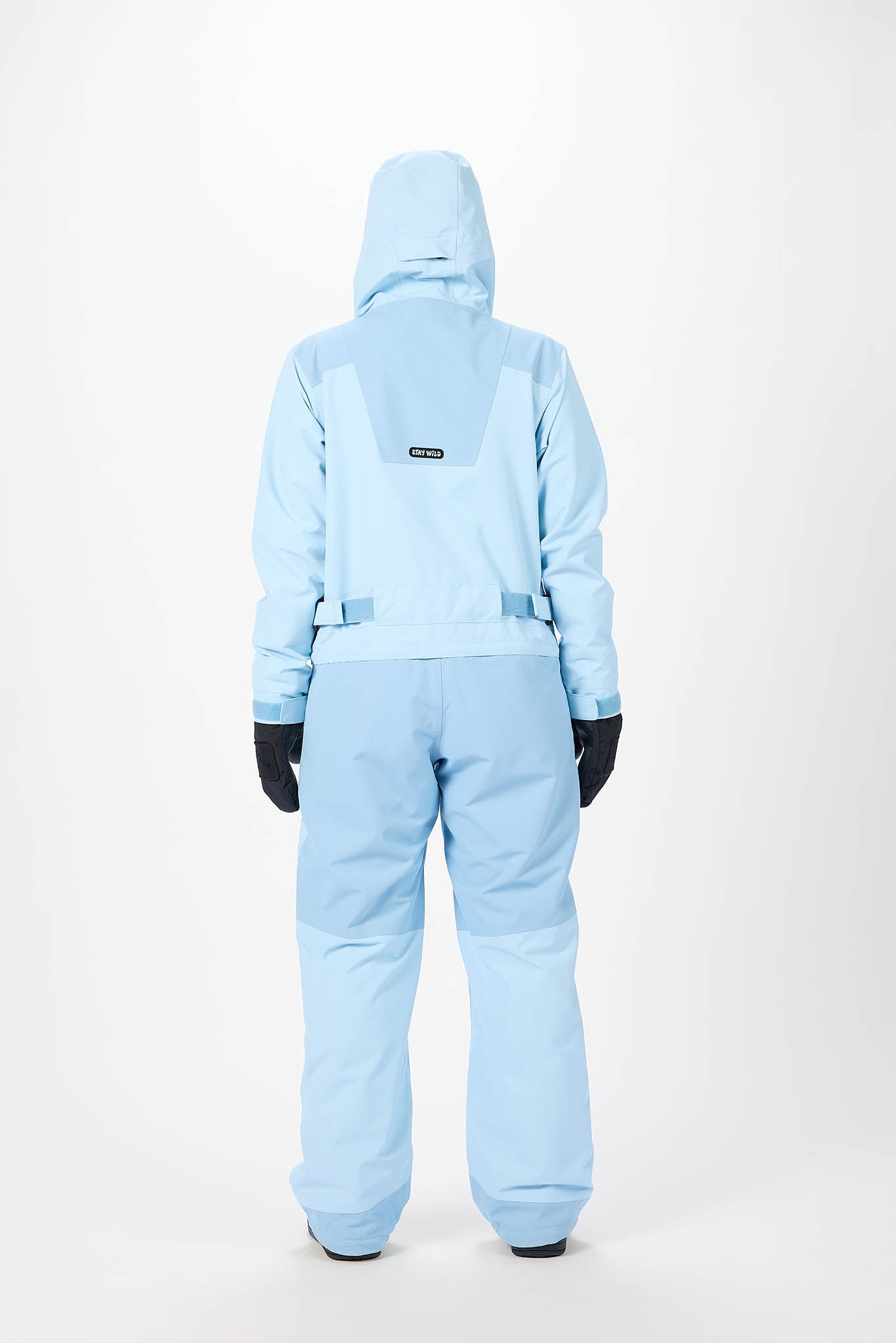 behind view Person wearing a light blue snowsuit on a white background
