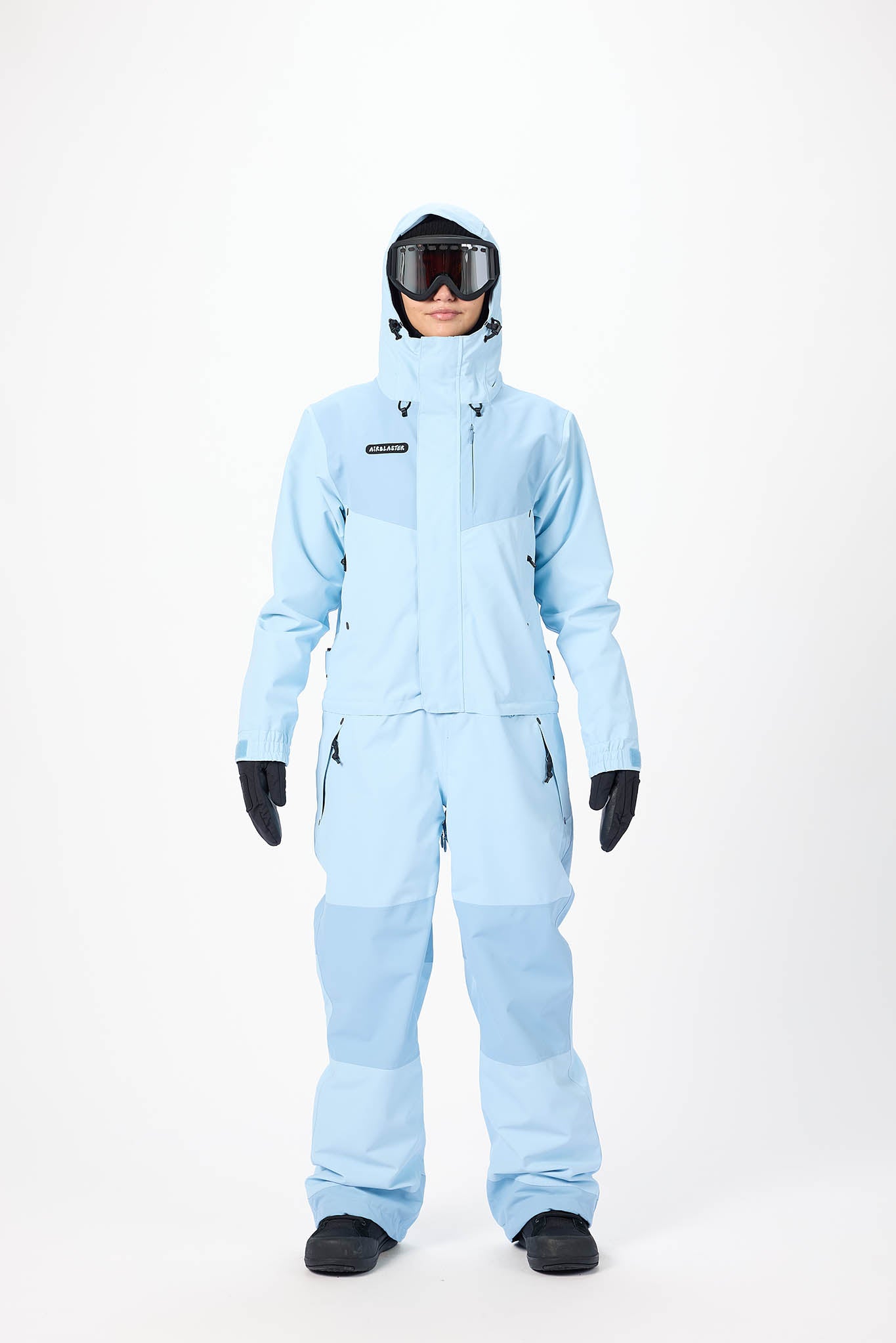 Person wearing a light blue snowsuit with a helmet on a white background