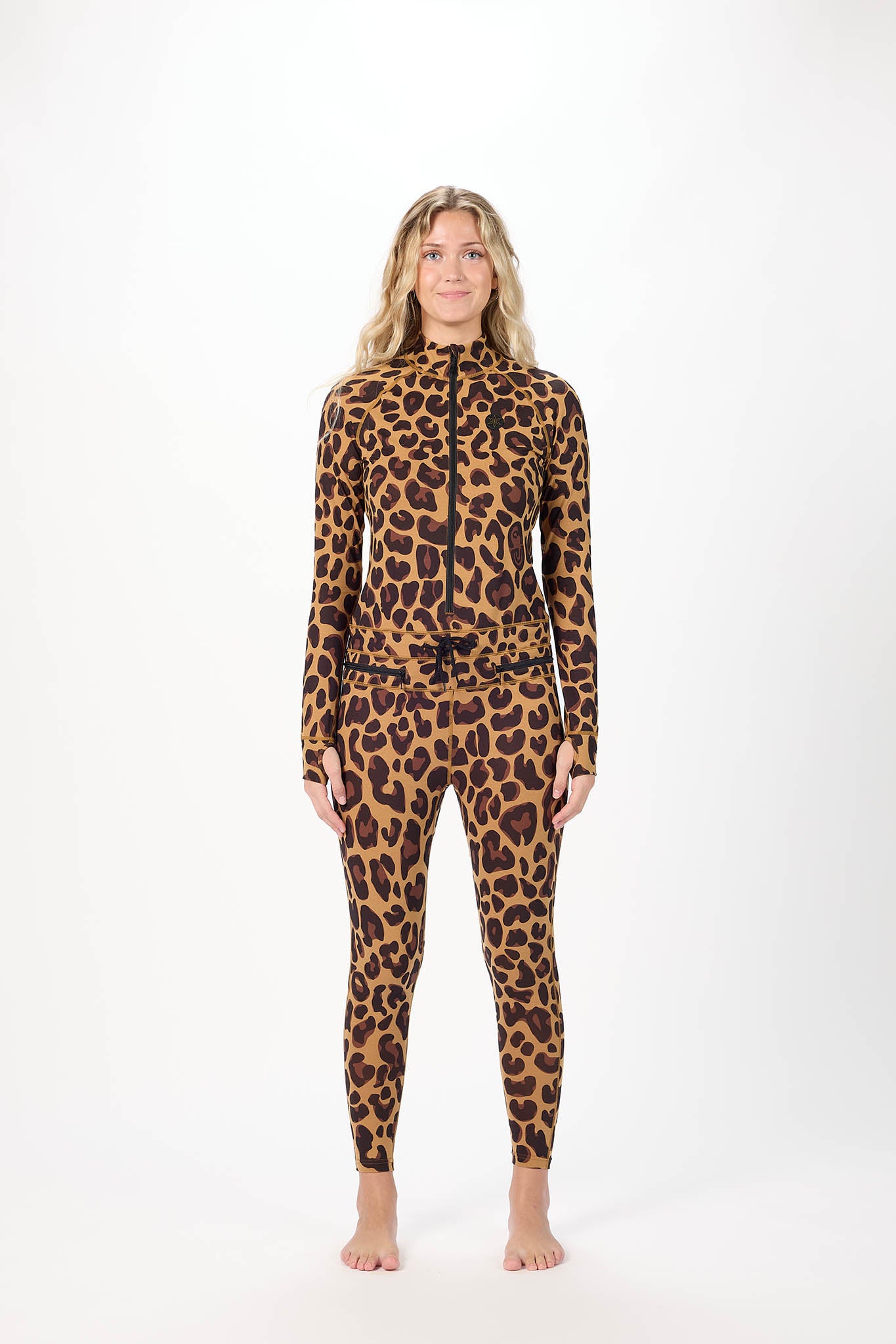A woman modeling a full-body leopard print zip-up one-piece jumpsuit against a plain white studio background.