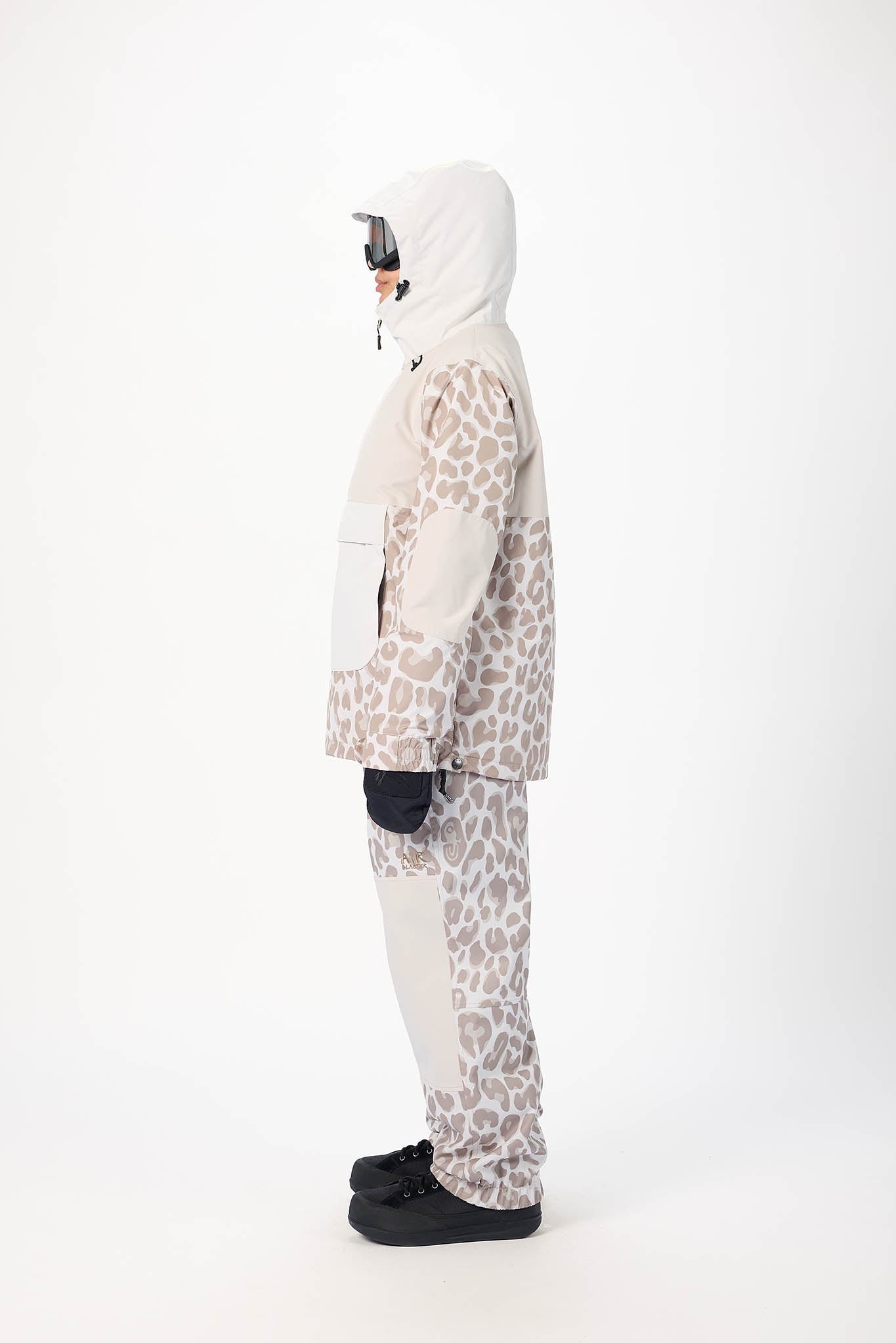 Person wearing a leopard print snowsuit on a white background