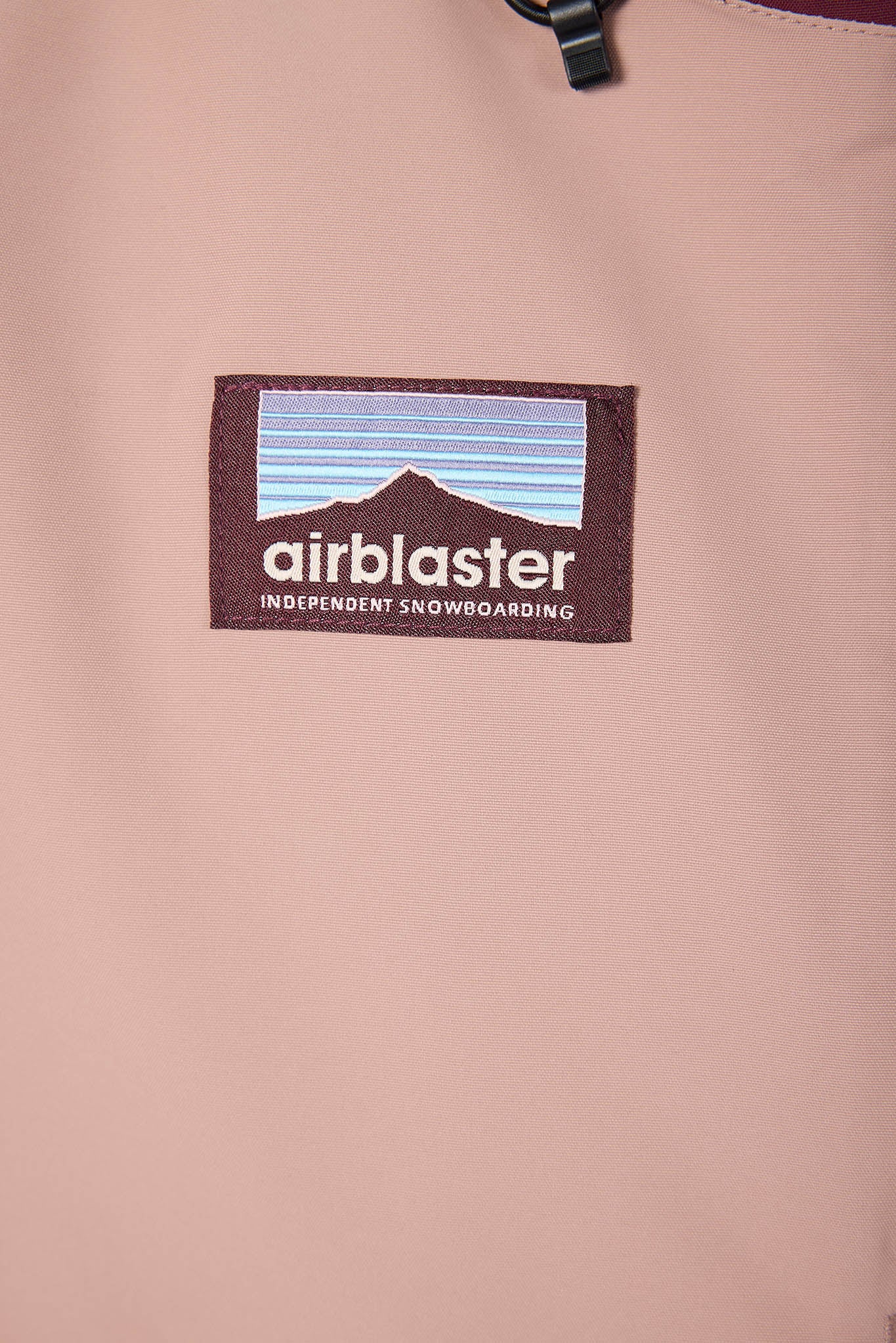 Close-up of an 'airblaster' logo on a pink jacket