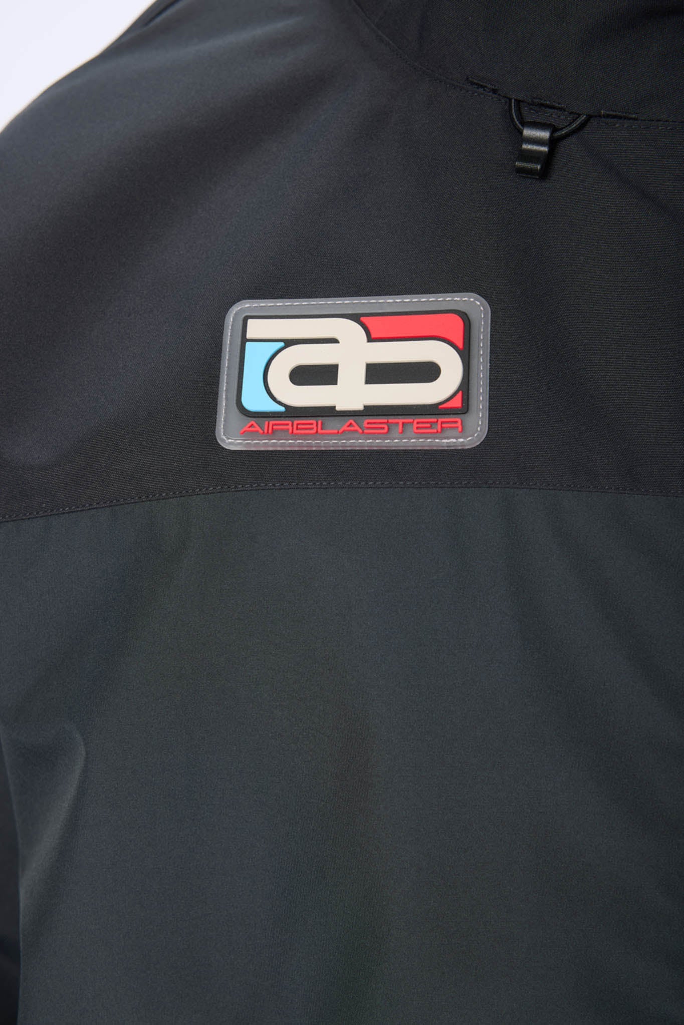 Black jacket with a brand logo patch featuring red, white, and blue colors.