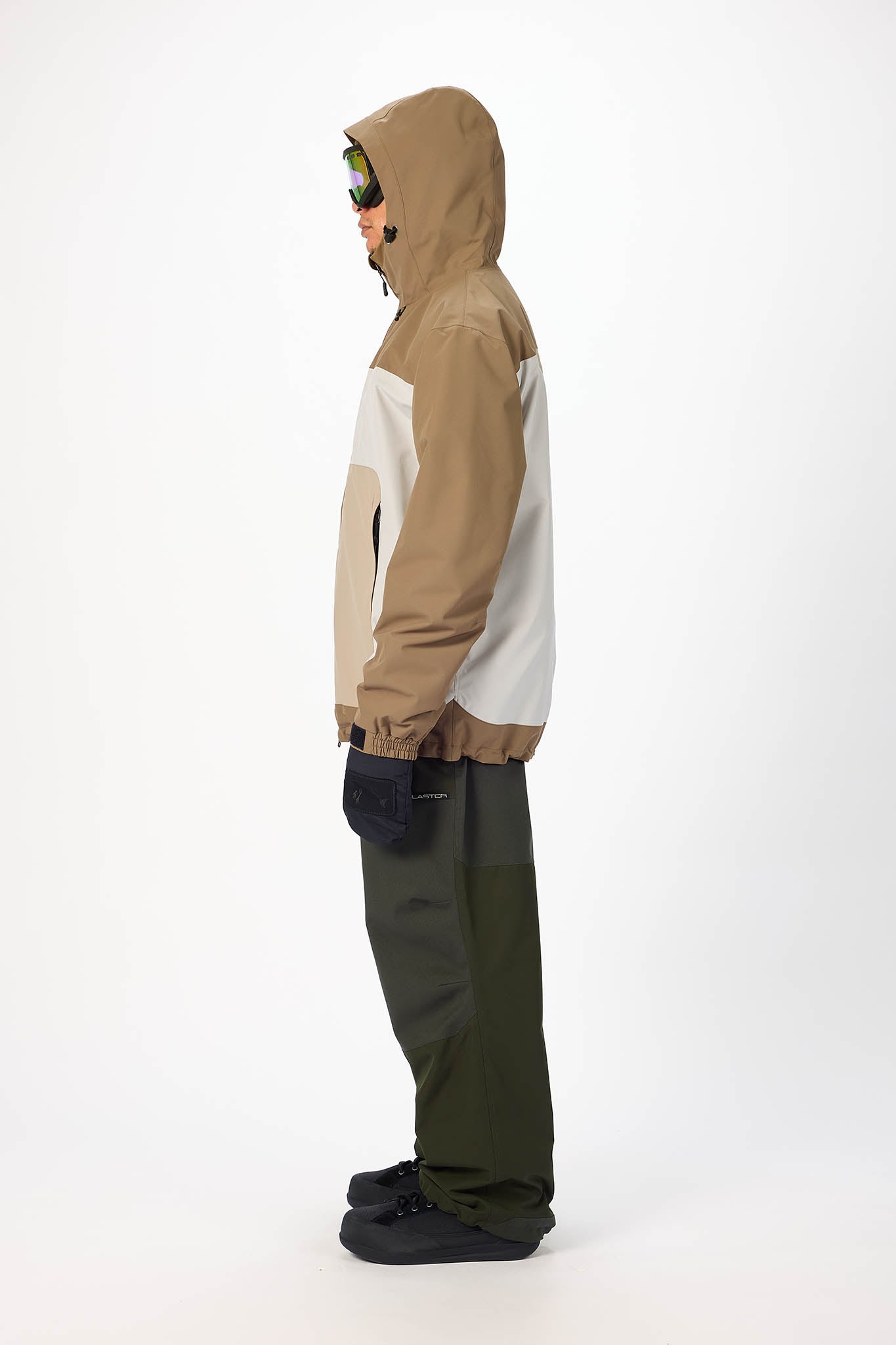 Person wearing a beige and white jacket with a hood, standing on a white background
