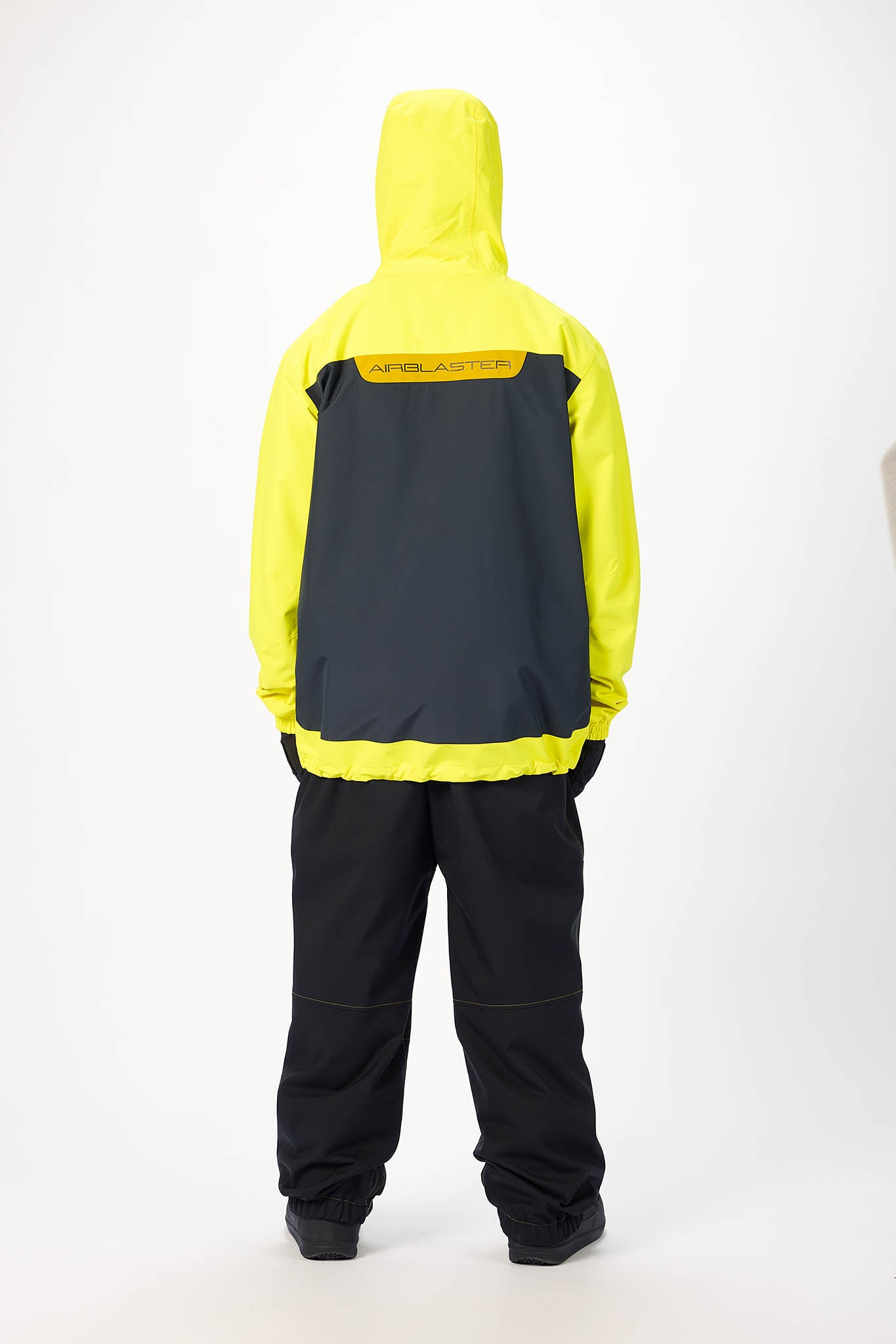 Person wearing a yellow and black raincoat with visible branding on a white background