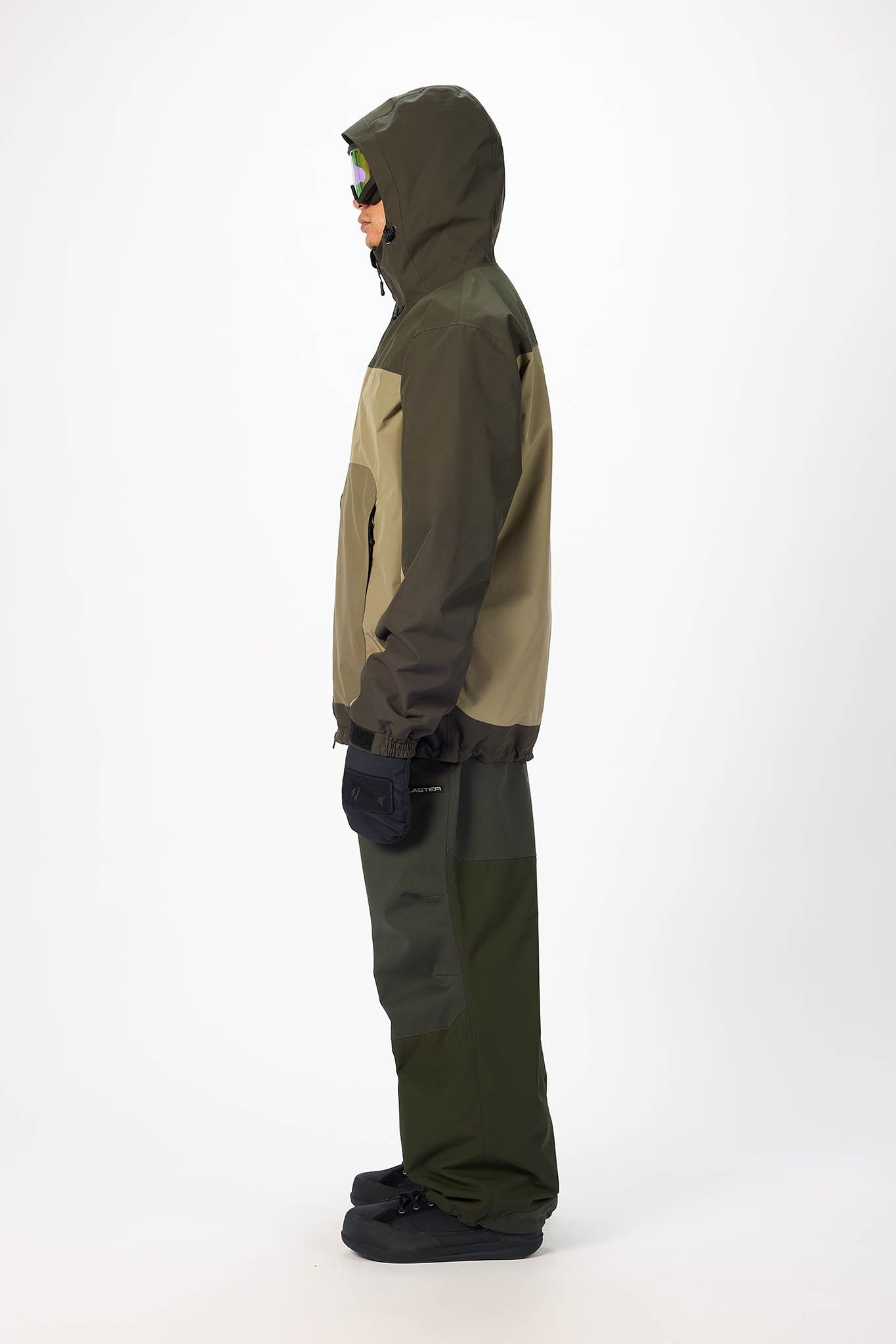 Person wearing a green and brown raincoat on a white background